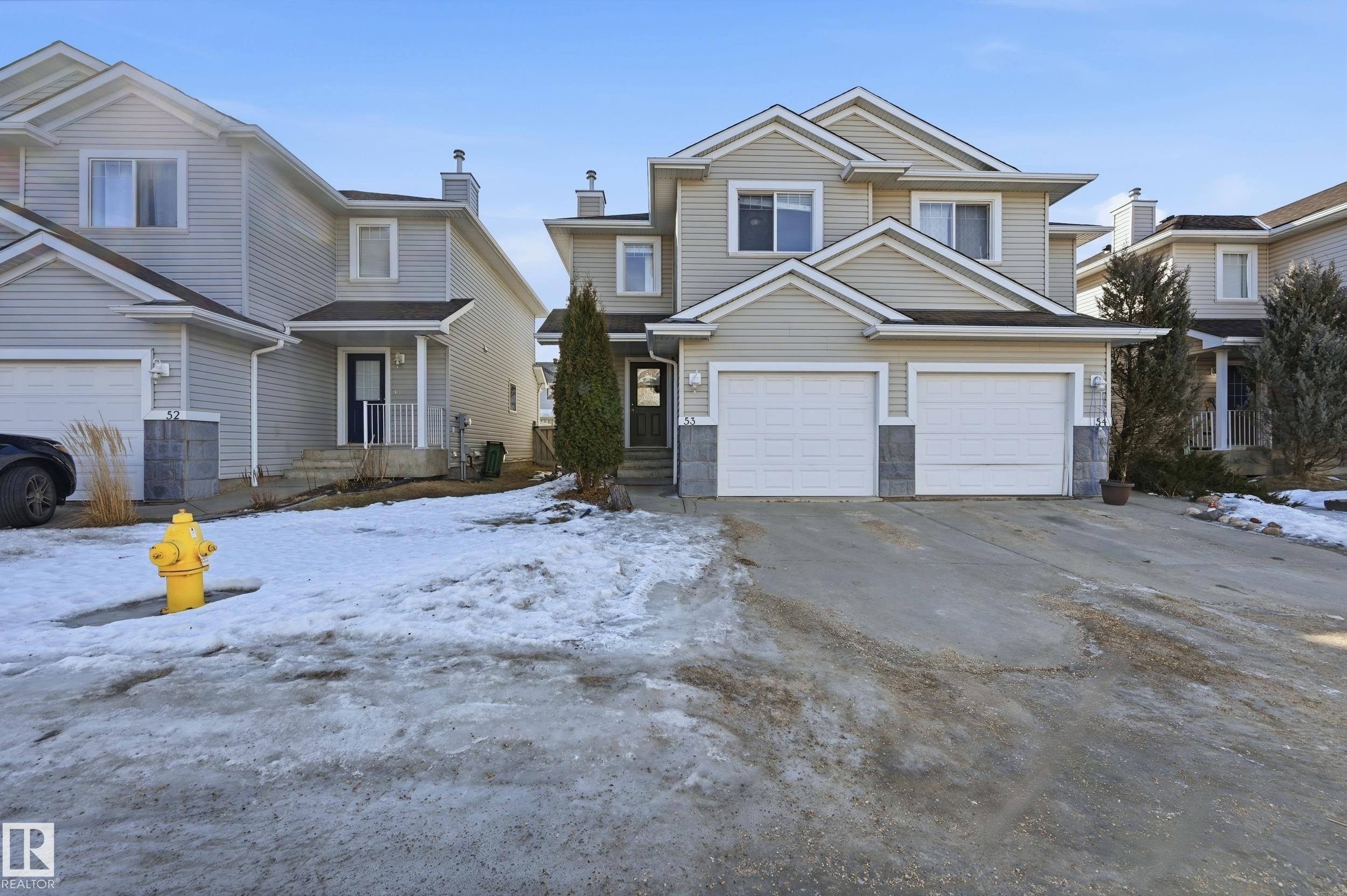 The property features a two-story exterior with light-colored siding and a two-car garage - 53 287 Macewan Road, Edmonton, AB - Outdoor With Facade