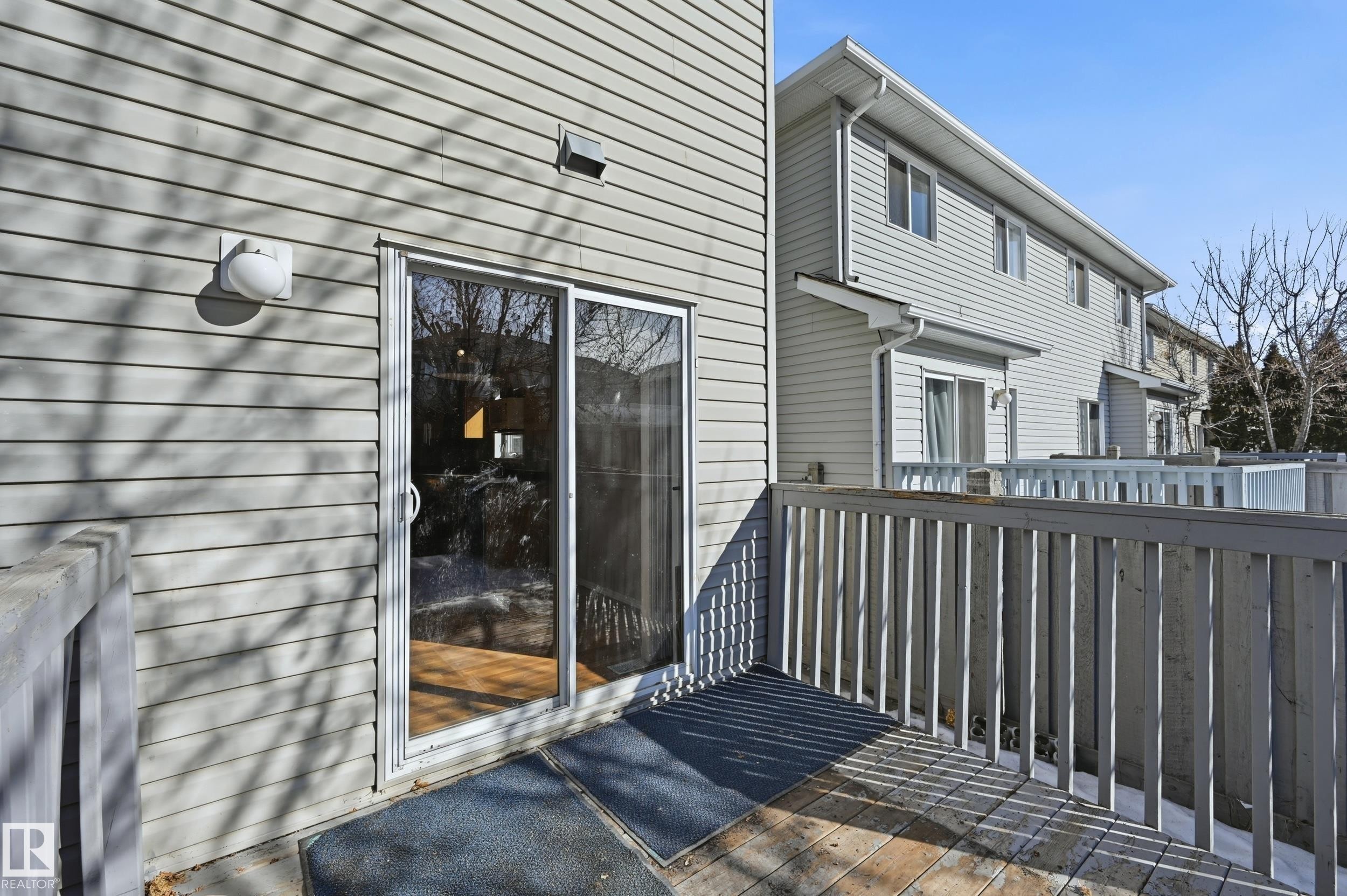 The property features a deck with a wooden railing, providing outdoor space - 53 287 Macewan Road, Edmonton, AB - Outdoor With Exterior