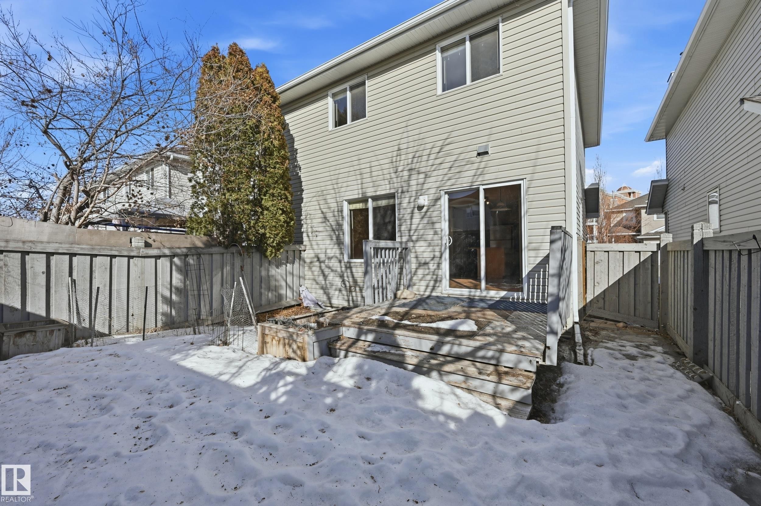 The property features a rear deck with direct access to the backyard, which is enclosed by a wooden fence - 53 287 Macewan Road, Edmonton, AB - Outdoor