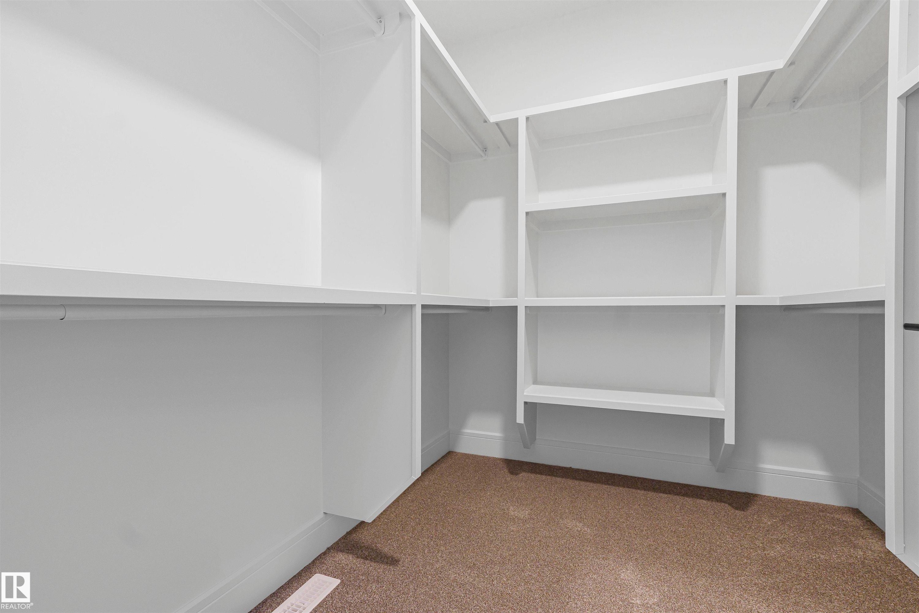 The property includes a walk-in closet with built-in white shelving and hanging rods - 368 Creekside Green, Leduc, AB - Indoor With Storage
