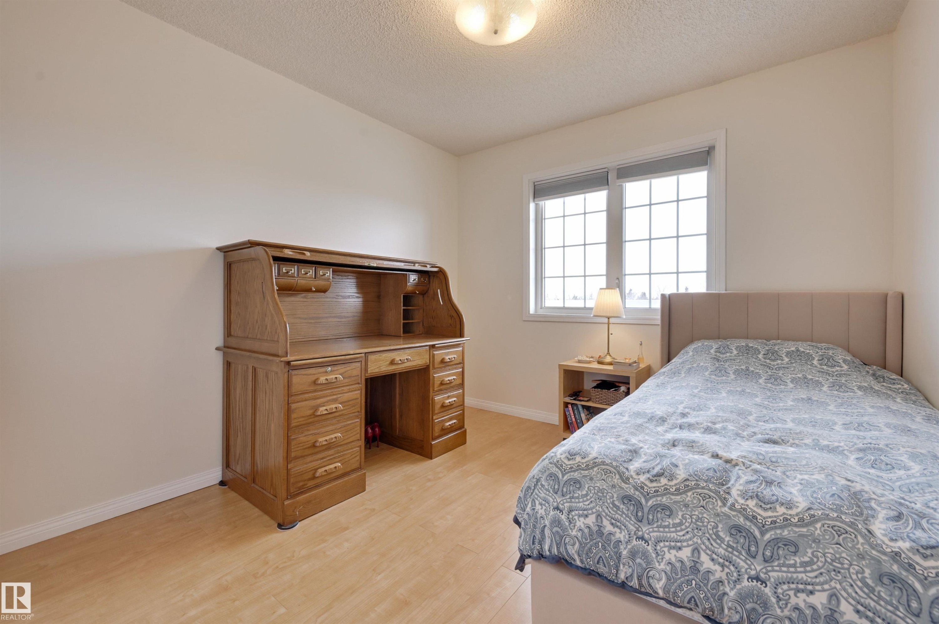 This room features light-colored flooring, a window with grid patterns, and a ceiling light fixture - 304 17151 94A Avenue, Edmonton, AB - Indoor Photo Showing Bedroom