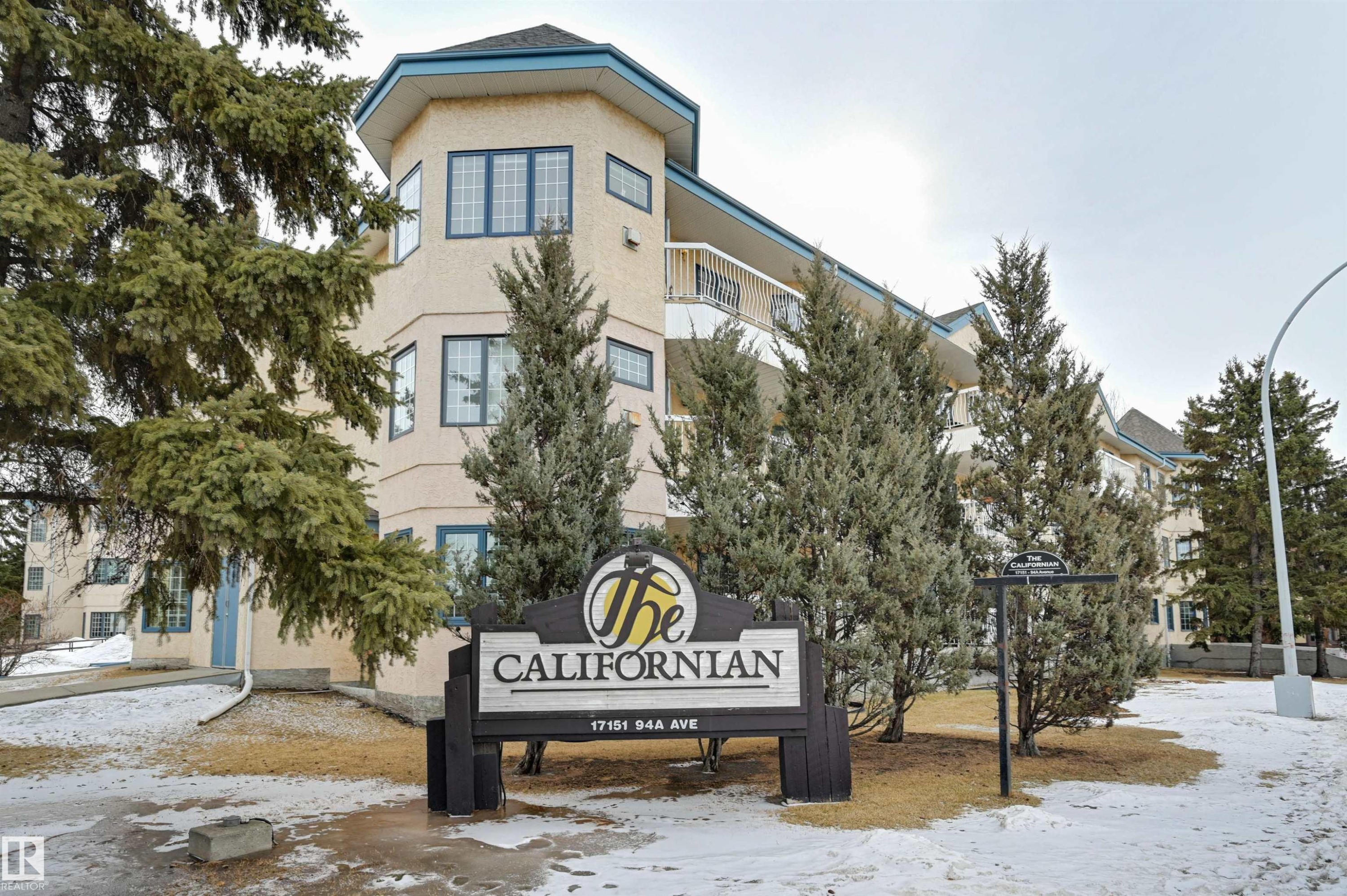 The property features an exterior with a light-colored finish and blue trim accents, along with several visible windows - 304 17151 94A Avenue, Edmonton, AB - Outdoor