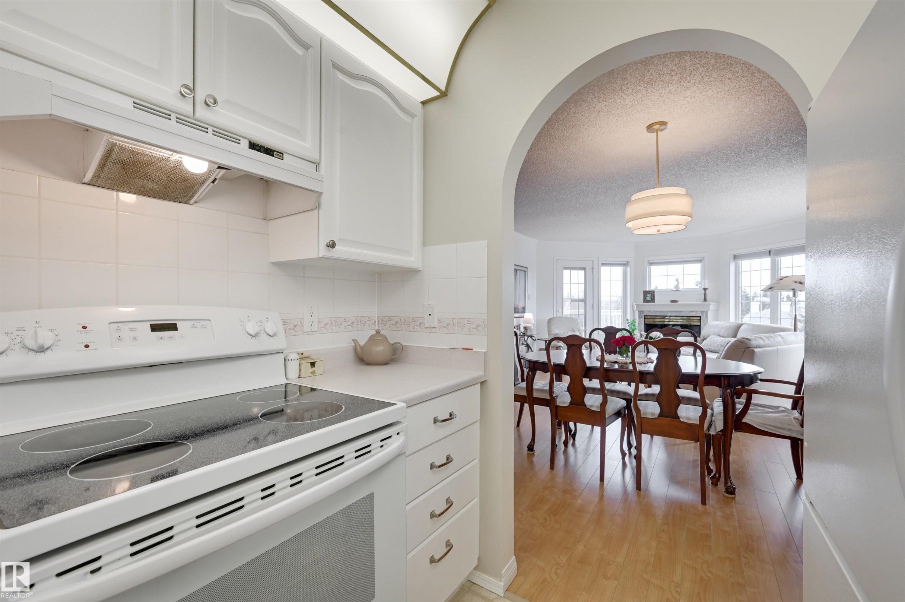 Kitchen featuring white cabinetry and appliances, including a range with a smooth cooktop - 304 17151 94A Avenue, Edmonton, AB - Indoor Photo Showing Kitchen