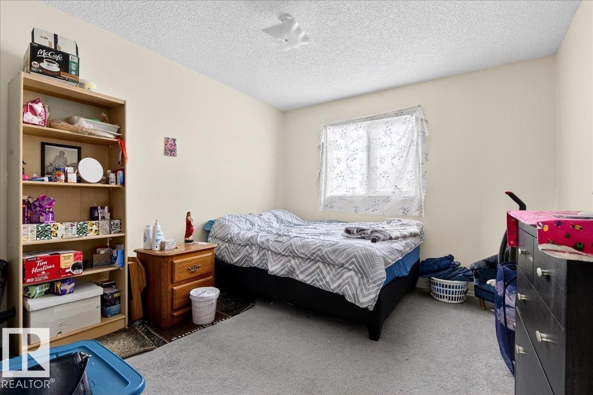 This room features light-colored walls and carpeting, with a window providing natural light - 13304 130 Avenue, Edmonton, AB - Indoor Photo Showing Bedroom