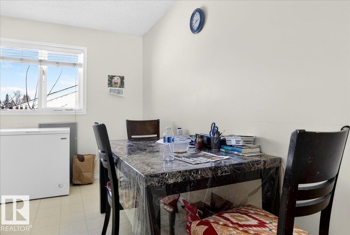 This room features a window providing natural light, a tiled floor, and a chest freezer - 13304 130 Avenue, Edmonton, AB - Indoor