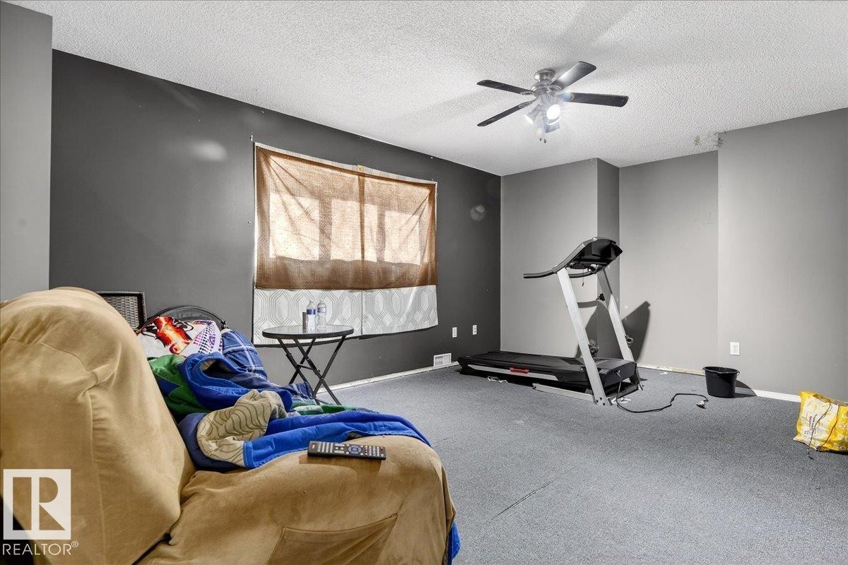 Room featuring grey walls, a ceiling fan with integrated lighting, and carpeted flooring - 13304 130 Avenue, Edmonton, AB - Indoor Photo Showing Gym Room