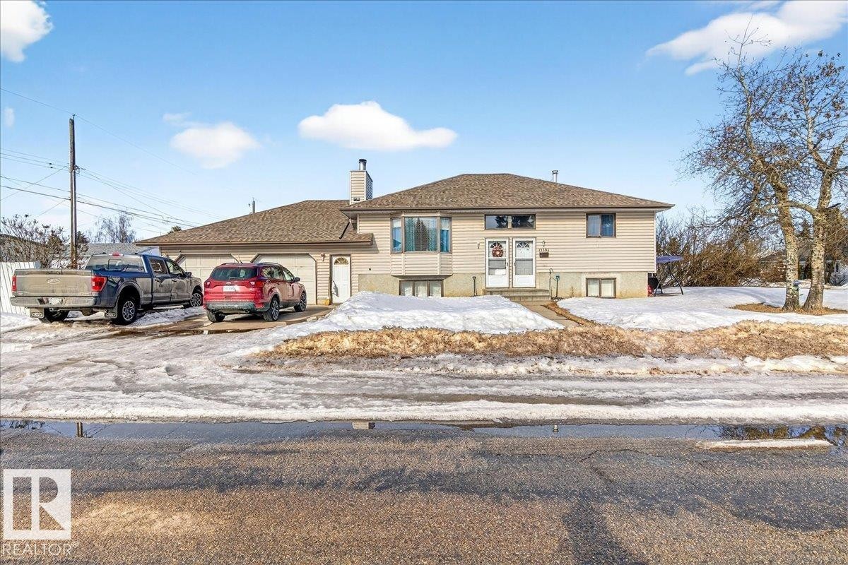 The property features a split-level design with light-colored siding and a brown roof - 13304 130 Avenue, Edmonton, AB - Outdoor