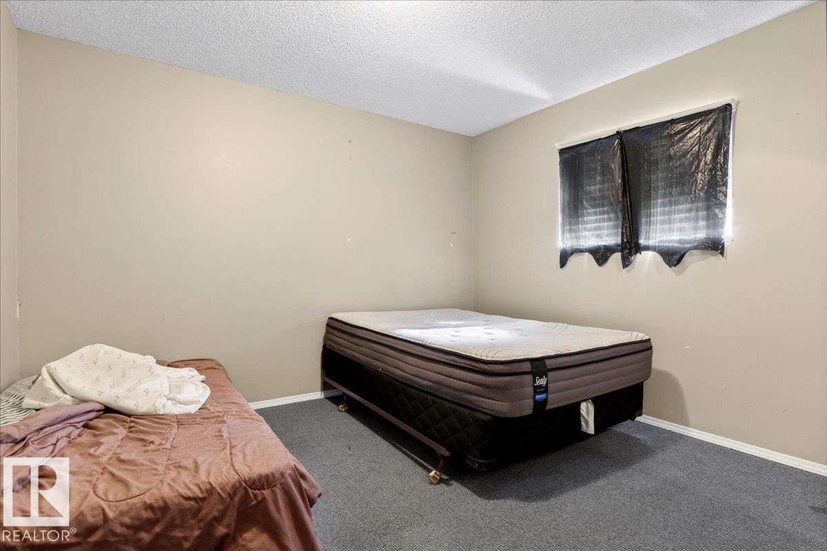 This room features wall-to-wall carpeting and neutral-toned walls - 13304 130 Avenue, Edmonton, AB - Indoor Photo Showing Bedroom