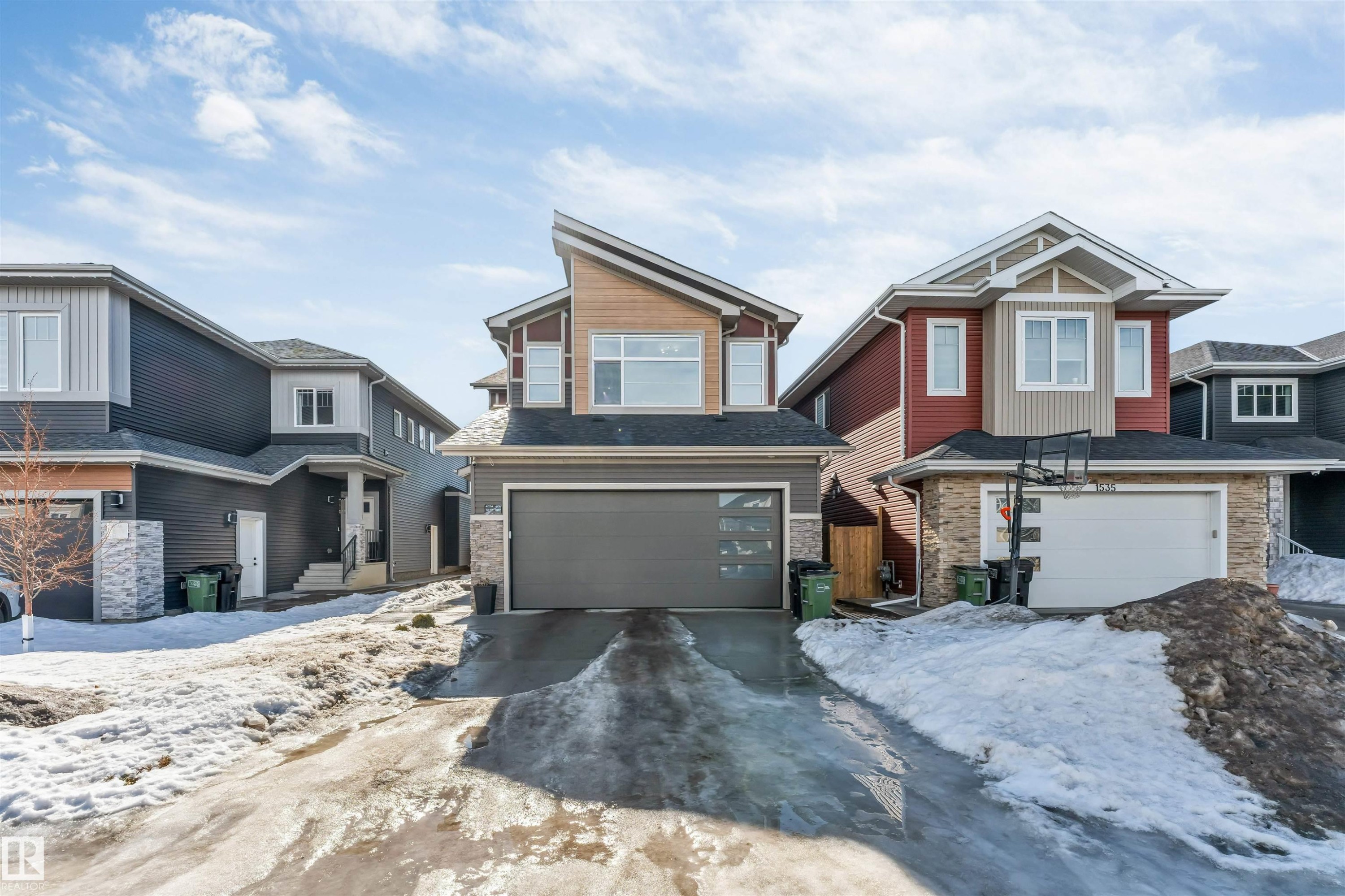 The property features a modern exterior with a grey garage door and a unique roofline - 1531 151 Avenue, Edmonton, AB - Outdoor With Facade