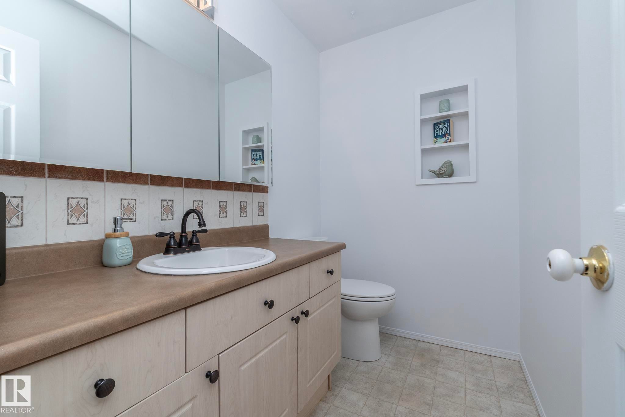 Bathroom featuring a vanity with a countertop, an integrated sink, a dark bronze faucet, and cabinetry with dark bronze hardware - 6 Glaewyn Estates, St. Albert, AB - Indoor Photo Showing Bathroom