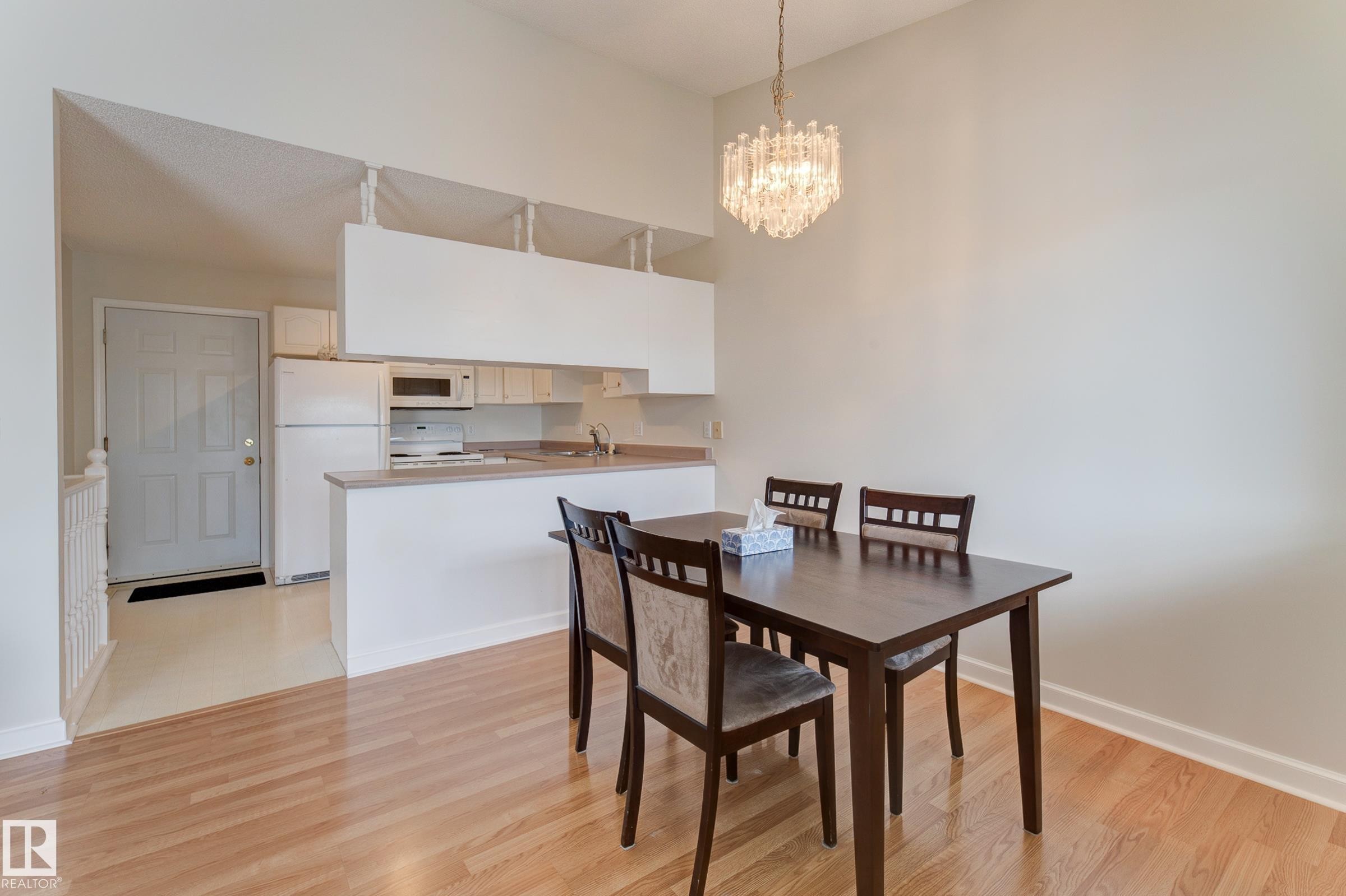 The property features a kitchen with white cabinetry and appliances, including a refrigerator, microwave, and stove - 5 308 Jackson Road, Edmonton, AB - Indoor