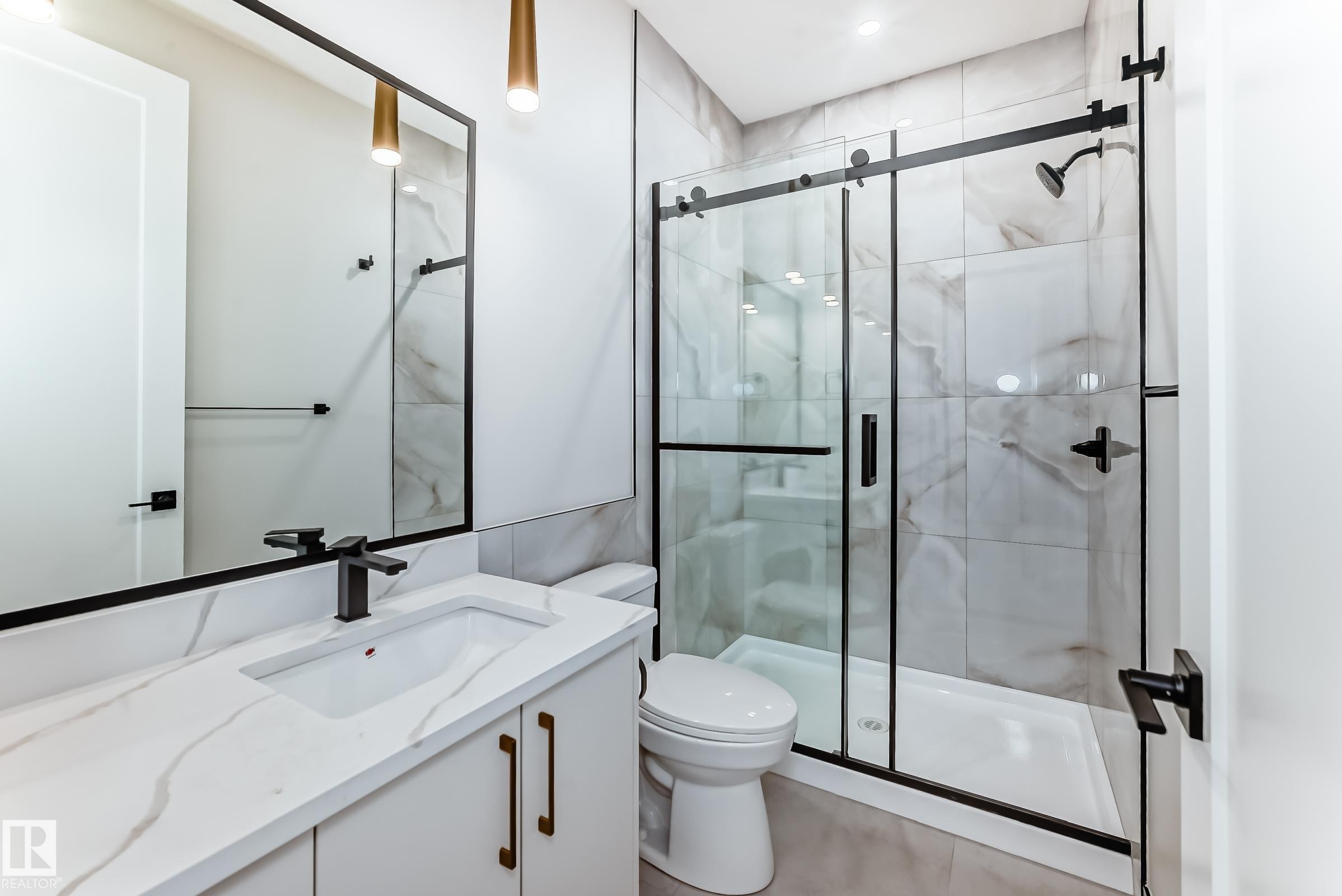 The bathroom features a modern vanity with a white countertop and rectangular sink, a large mirror with a black frame, and a clear glass shower with black framing and fixtures - 7665 Kimiwan Crescent, Edmonton, AB - Indoor Photo Showing Bathroom