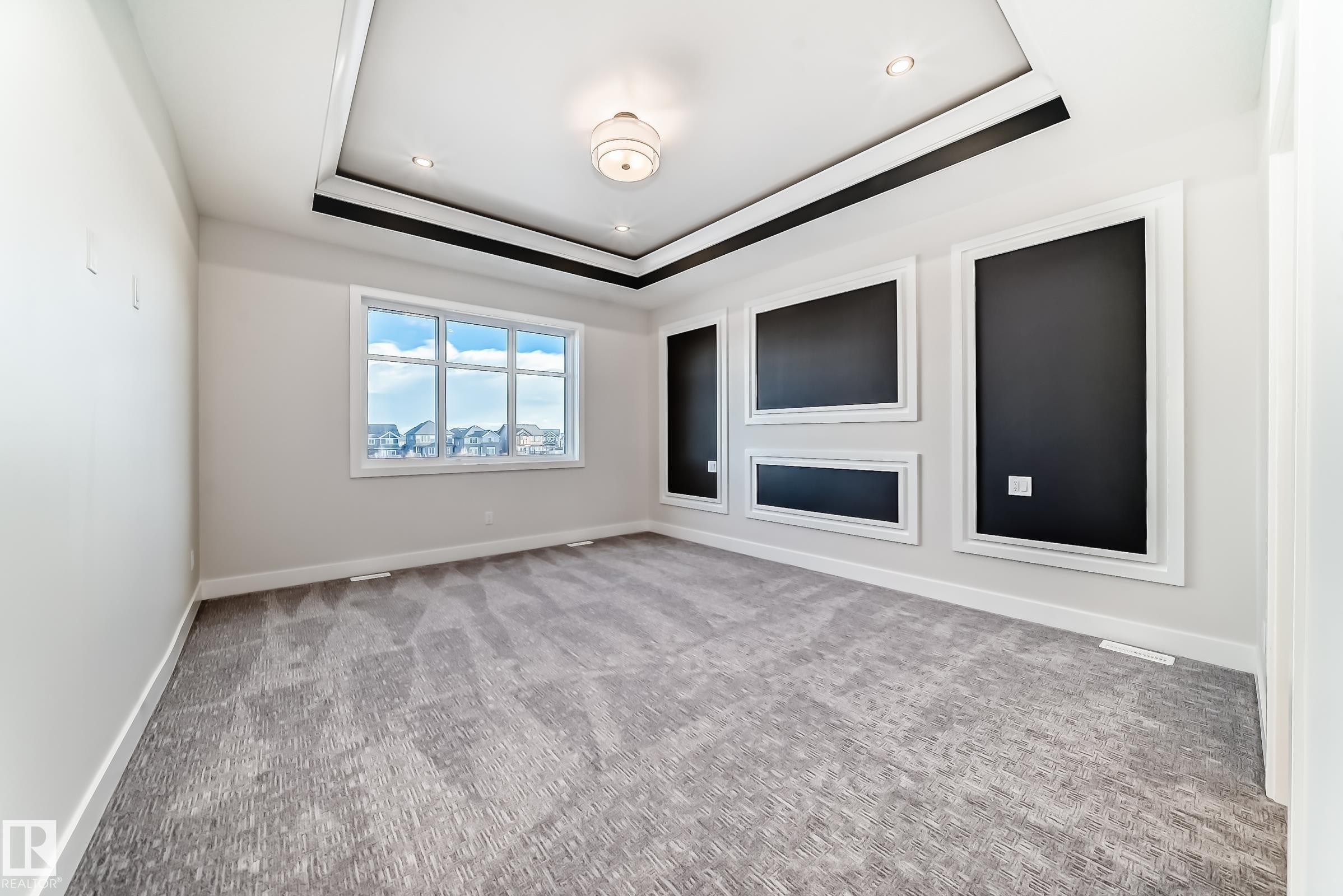 This spacious room features a tray ceiling with recessed lighting and a central light fixture - 7665 Kimiwan Crescent, Edmonton, AB - Indoor Photo Showing Other Room