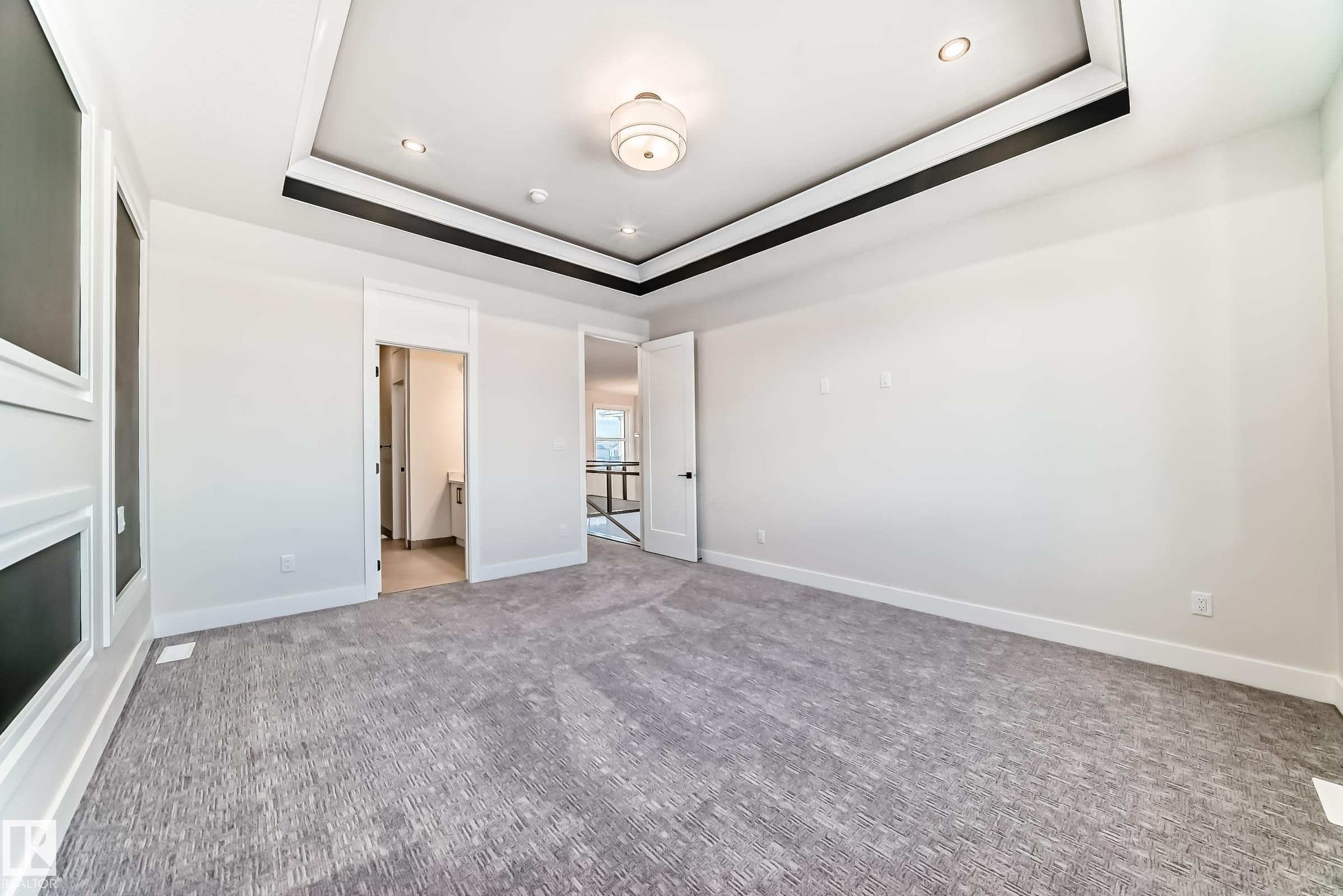 This room features a tray ceiling with recessed lighting and a central light fixture, along with a patterned carpet - 7665 Kimiwan Crescent, Edmonton, AB - Indoor Photo Showing Other Room With Fireplace