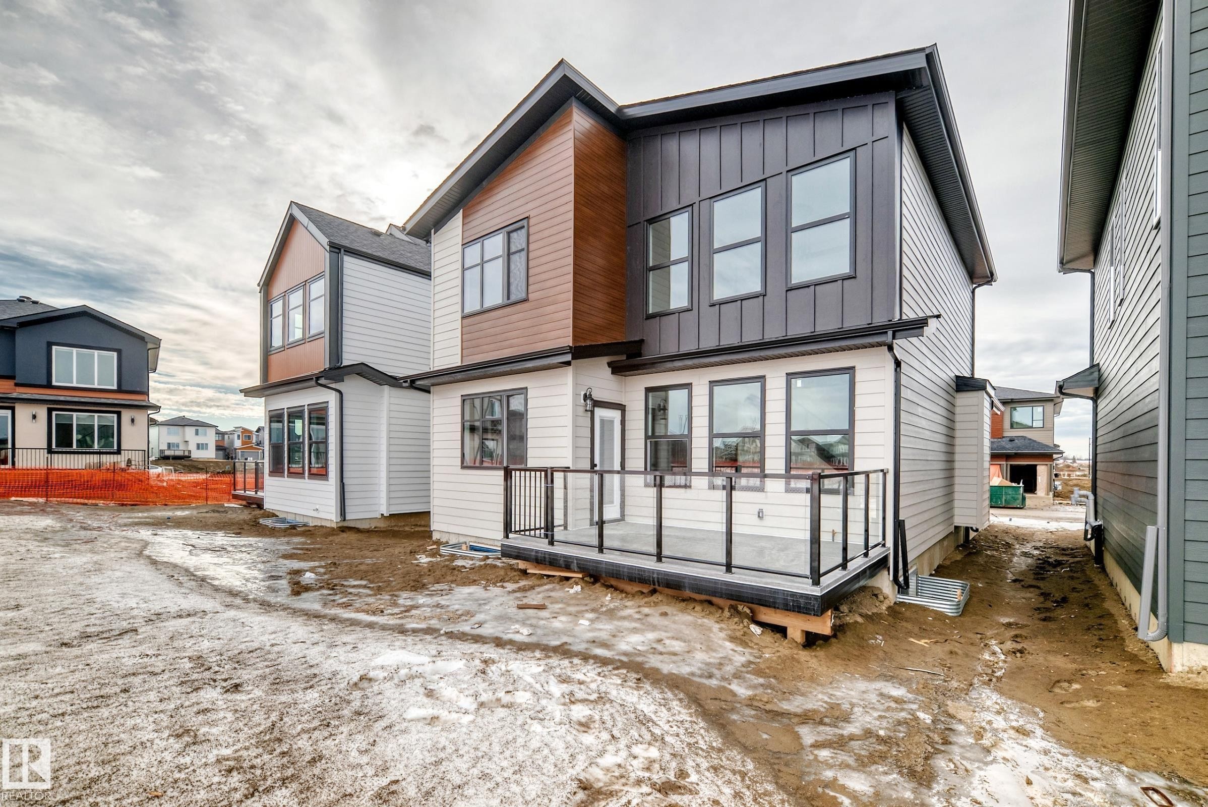 The property features a modern exterior design with mixed siding, including light-colored horizontal siding, dark vertical siding, and wood-toned paneling - 7665 Kimiwan Crescent, Edmonton, AB - Outdoor With Exterior