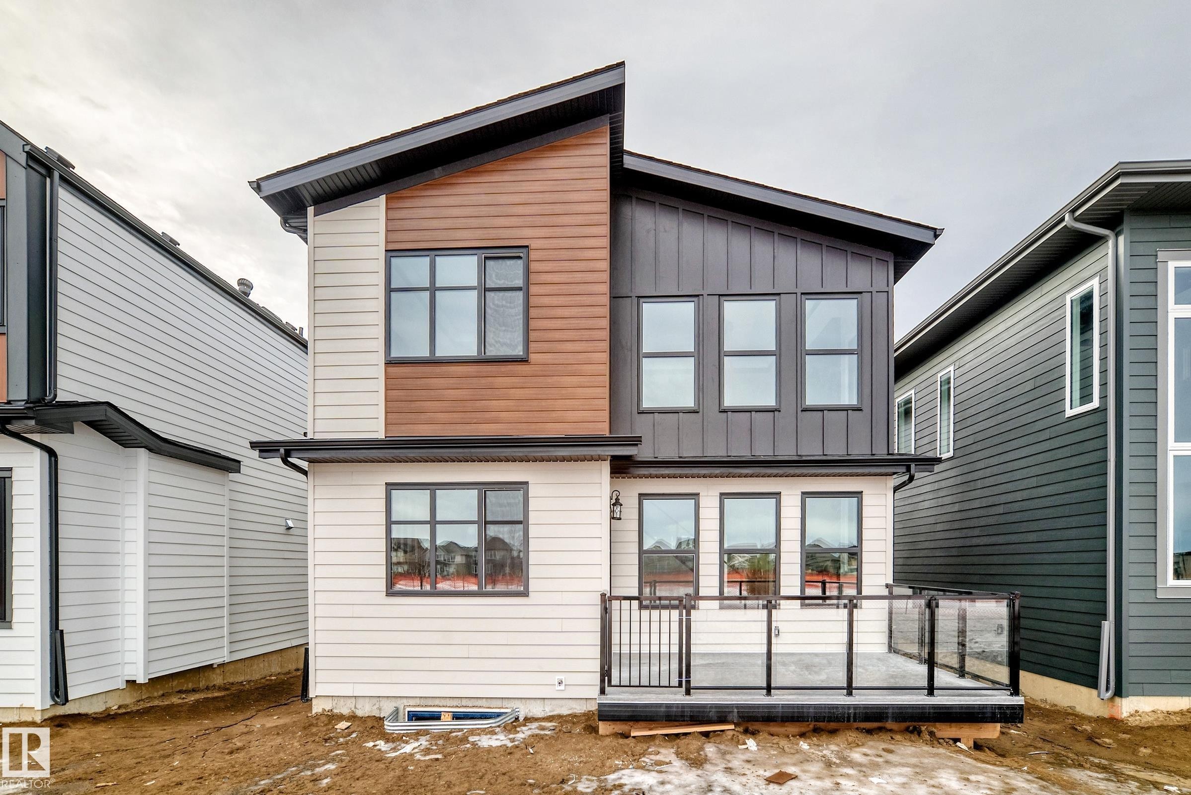 The property features a contemporary design with a combination of light-colored siding, natural wood-tone accents, and dark vertical paneling - 7665 Kimiwan Crescent, Edmonton, AB - Outdoor With Exterior