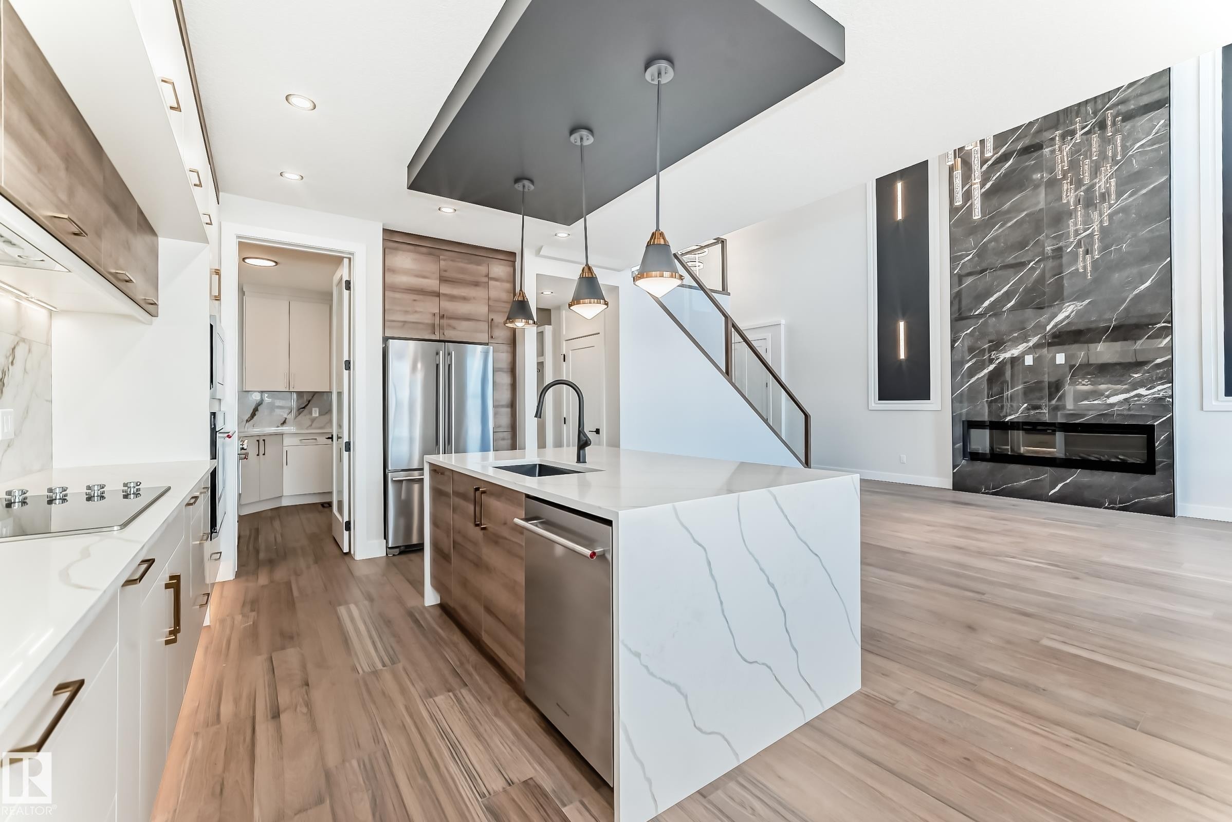 The property features an open-concept layout with light-toned flooring throughout - 7665 Kimiwan Crescent, Edmonton, AB - Indoor Photo Showing Kitchen With Upgraded Kitchen