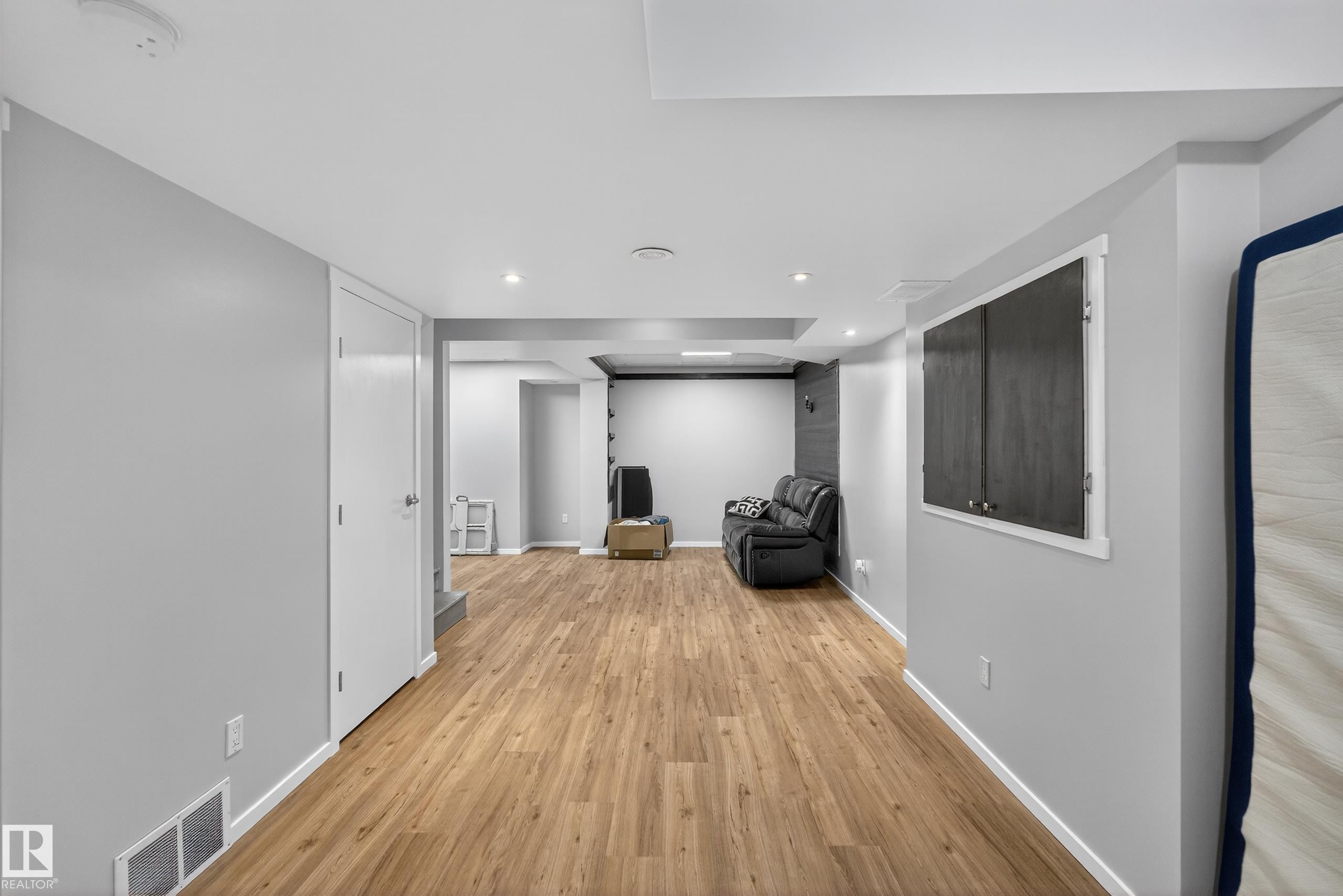 Spacious room featuring light wood flooring, light gray walls, and recessed lighting - 1522 Chapman Way, Edmonton, AB - Indoor Photo Showing Other Room