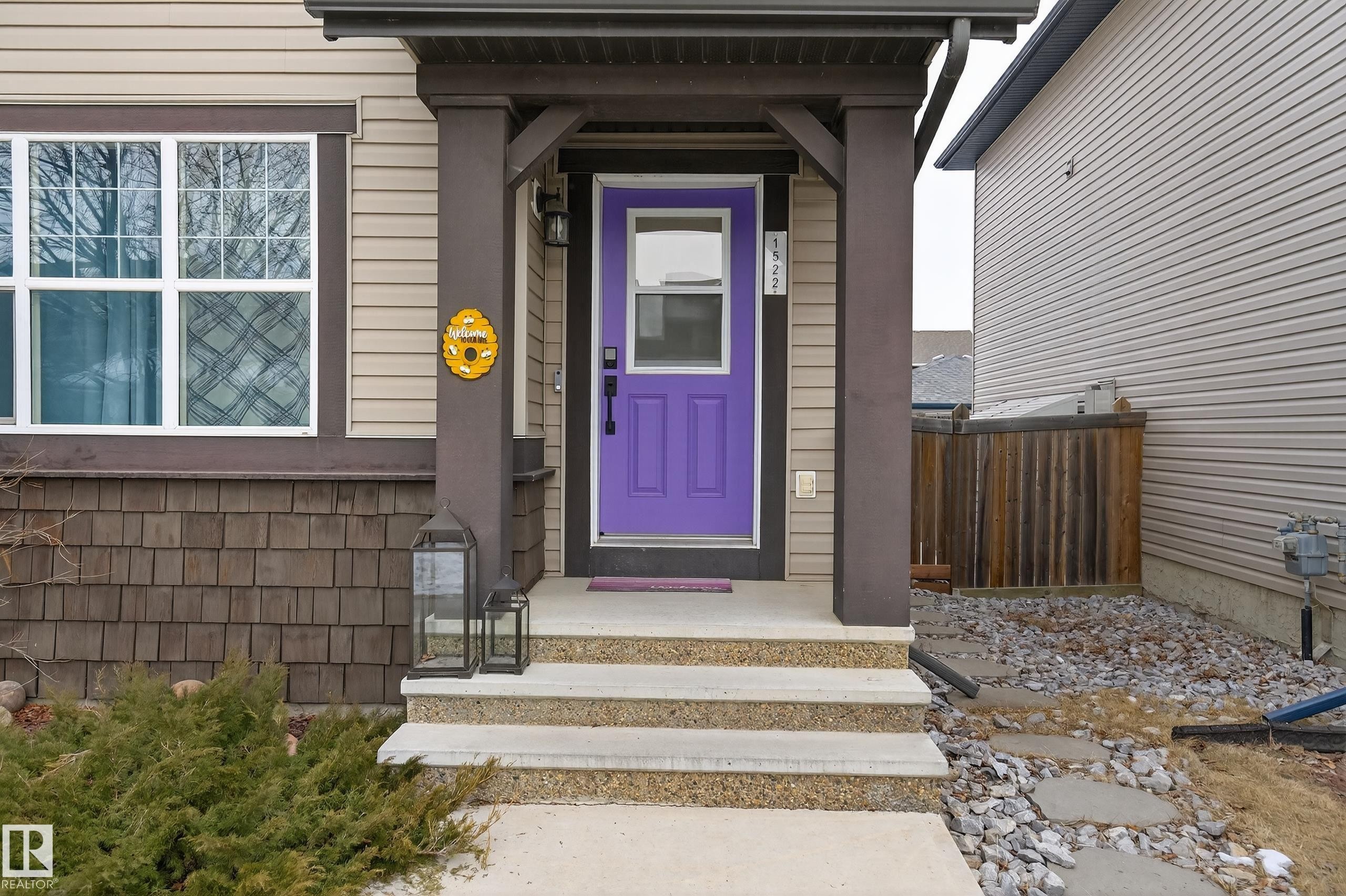 The property features a welcoming entrance with a vibrant purple door, concrete steps, and a covered porch - 1522 Chapman Way, Edmonton, AB - Outdoor With Exterior