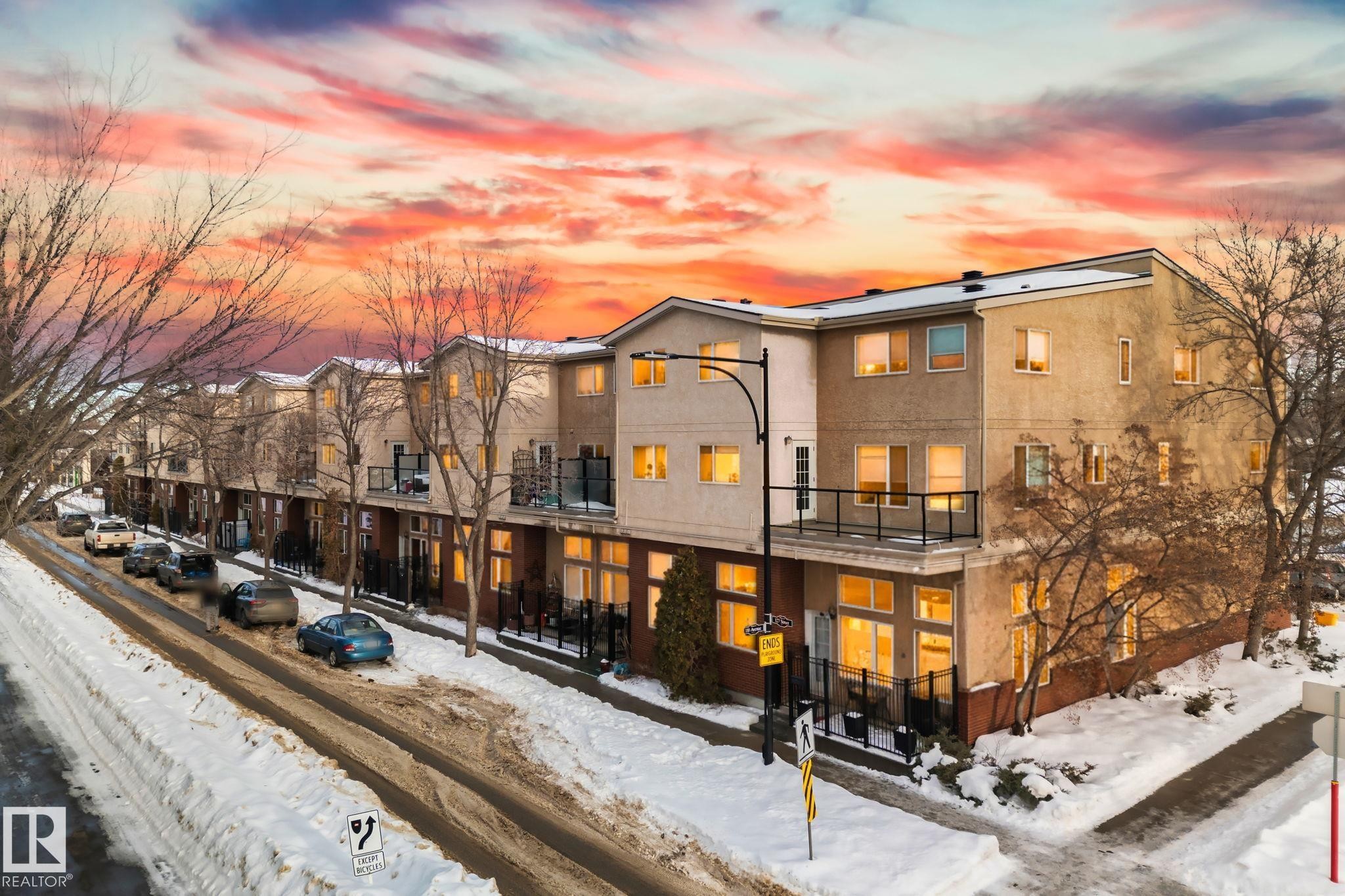 The property features a multi-story exterior with balconies and ground-floor patios - 116 11033 127 Street, Edmonton, AB - Outdoor