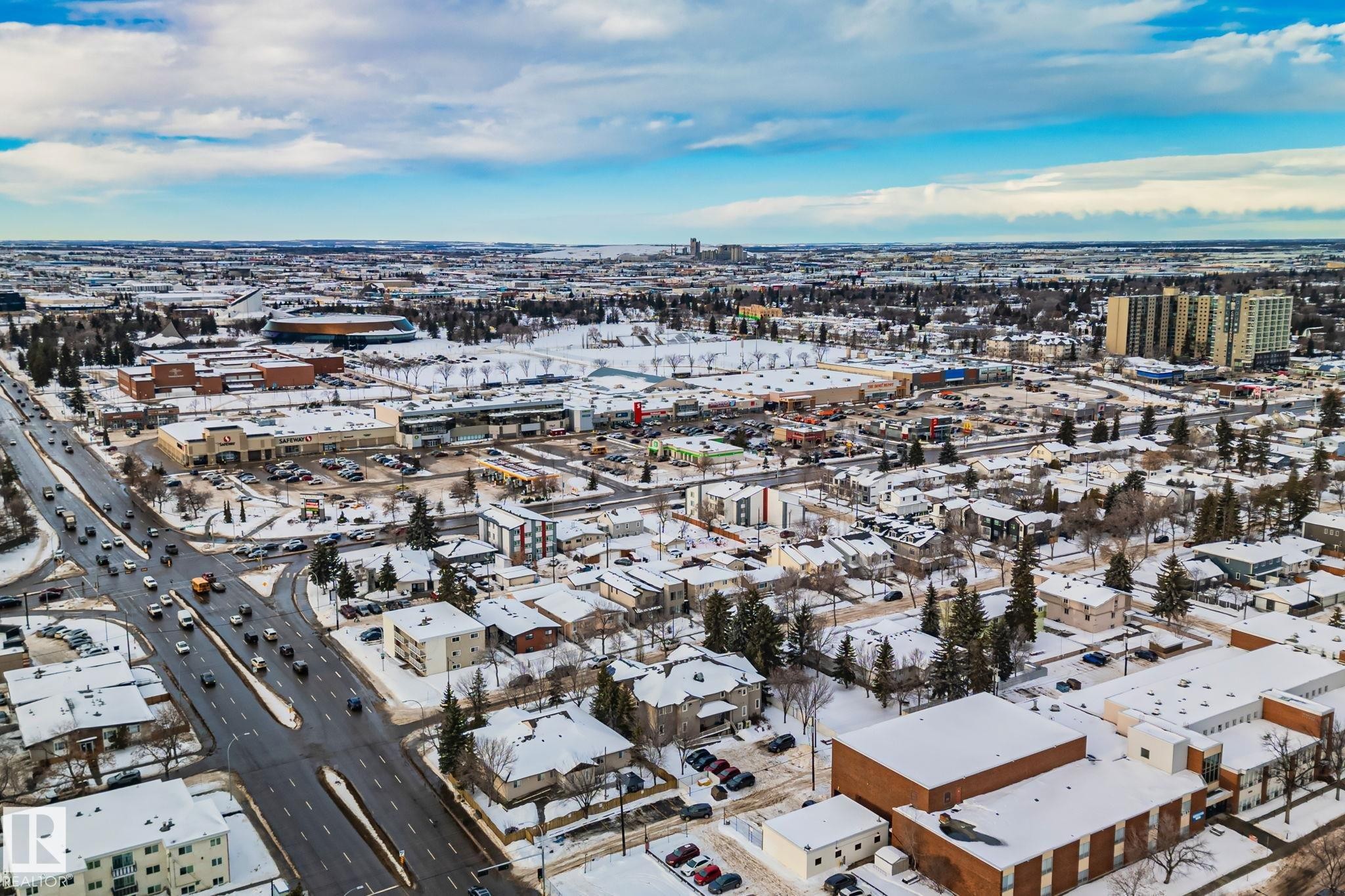 Aerial view of the surrounding area featuring roads with vehicles, various buildings, and snow-covered landscapes - 116 11033 127 Street, Edmonton, AB - Outdoor With View