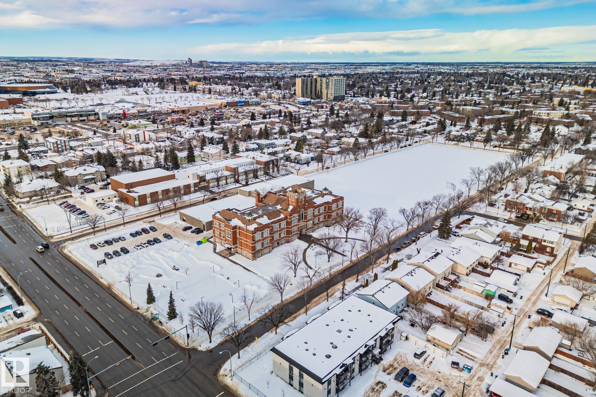 The property is set within a residential neighborhood featuring established trees, nearby park space, and a well-maintained street - 116 11033 127 Street, Edmonton, AB - Outdoor With View