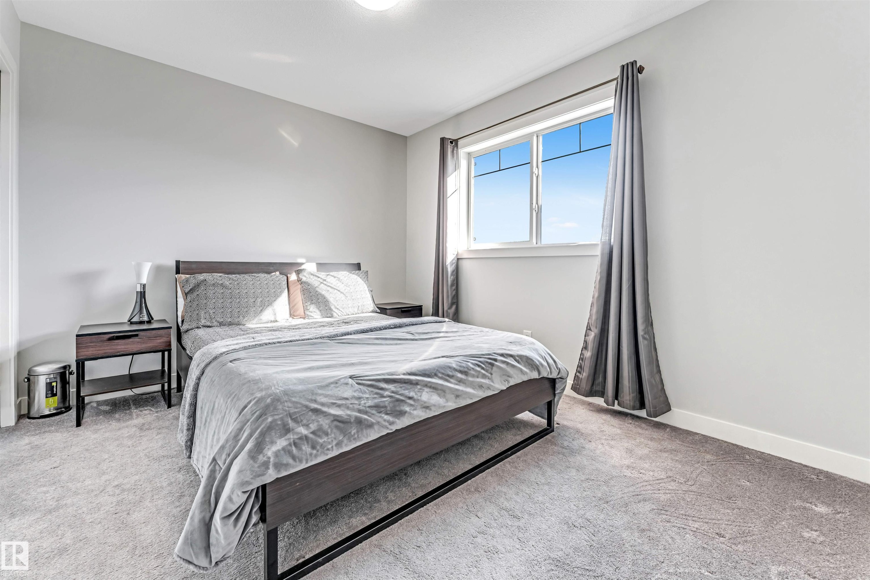 This bedroom features neutral-toned walls, a window with curtains, and a carpeted floor - 2244 21 Avenue, Edmonton, AB - Indoor Photo Showing Bedroom