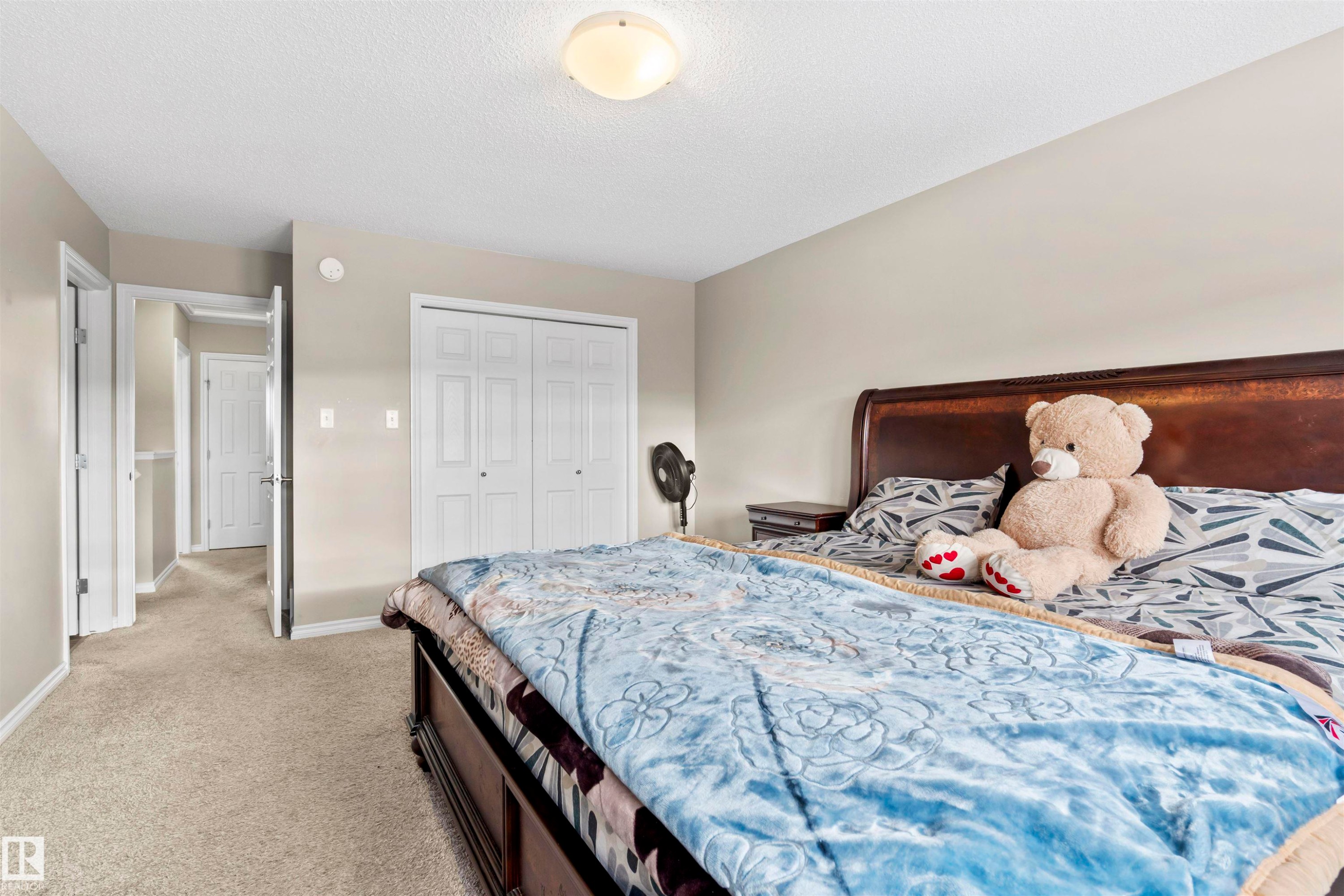 Bedroom featuring light carpet, a closet, and a textured ceiling - 2526 19A Avenue Nw, Edmonton, AB - Indoor Photo Showing Bedroom