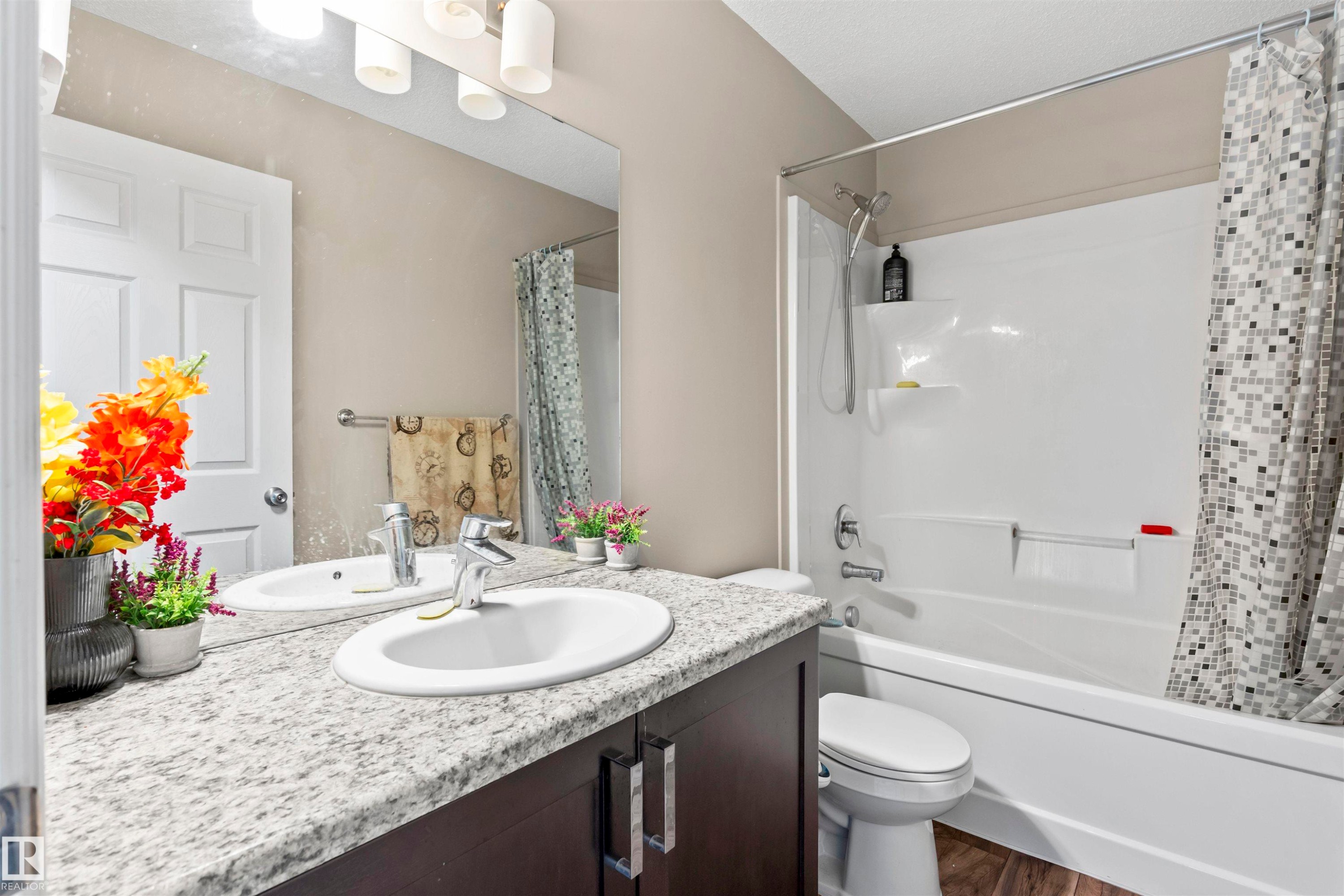 Full bathroom with vanity, shower / tub combo with curtain, and dark wood-style floors - 2526 19A Avenue Nw, Edmonton, AB - Indoor Photo Showing Bathroom