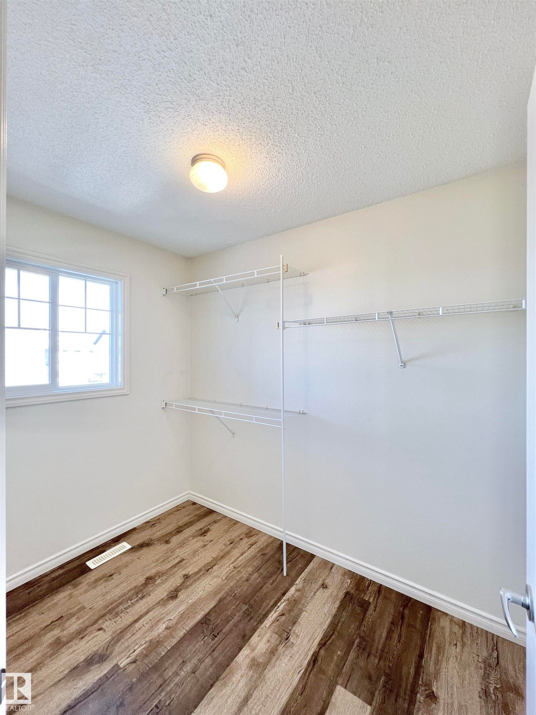 This room features a window, light-colored walls, and wood-look flooring - 17127 7A Avenue, Edmonton, AB - Indoor