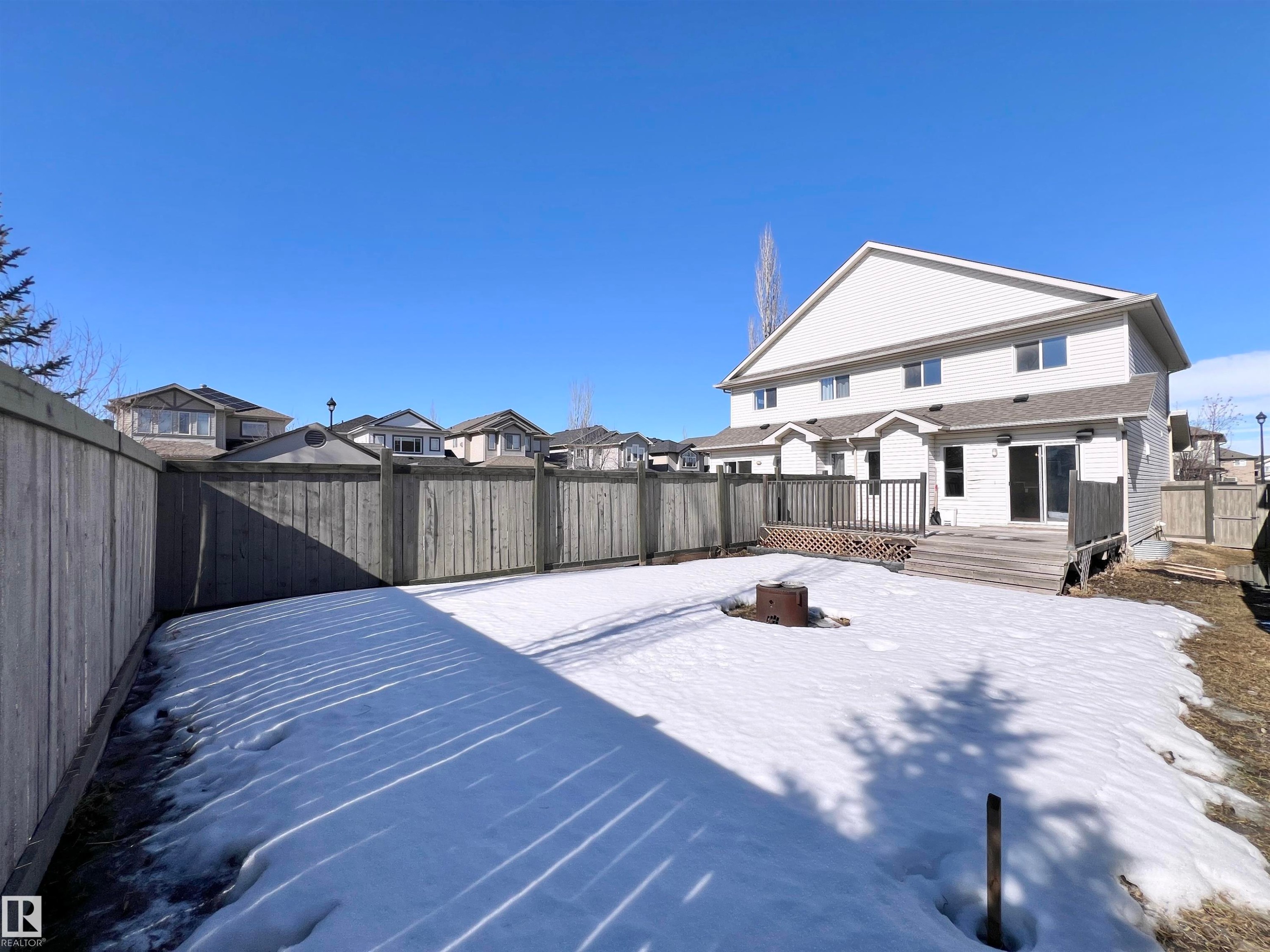 The property features a white exterior with multiple windows and a back deck - 17127 7A Avenue, Edmonton, AB - Outdoor