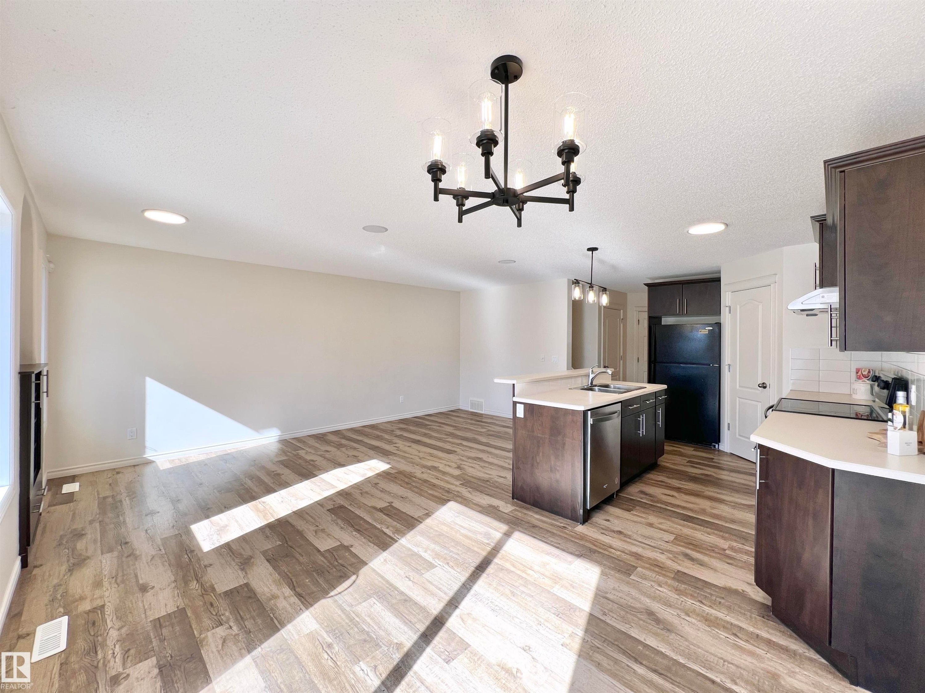 Open concept living area featuring wood-look flooring and recessed lighting - 17127 7A Avenue, Edmonton, AB - Indoor Photo Showing Kitchen