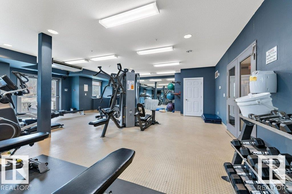 Well-equipped fitness area featuring various exercise machines, free weights, and a durable floor surface - 145 10121 80 Avenue, Edmonton, AB - Indoor Photo Showing Gym Room