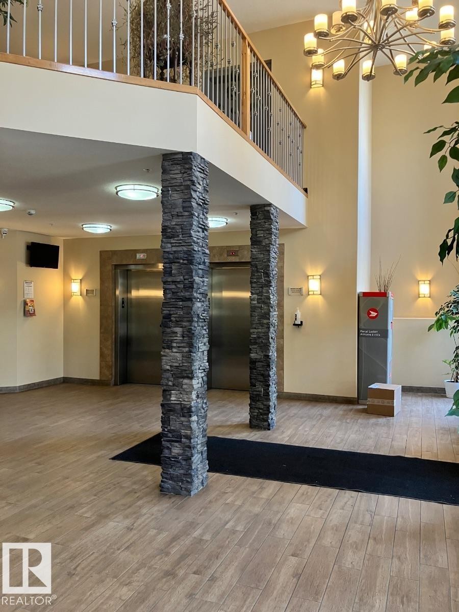 Entryway featuring wood-look flooring, stone-clad pillars, and recessed ceiling lighting - 145 10121 80 Avenue, Edmonton, AB - Indoor Photo Showing Other Room