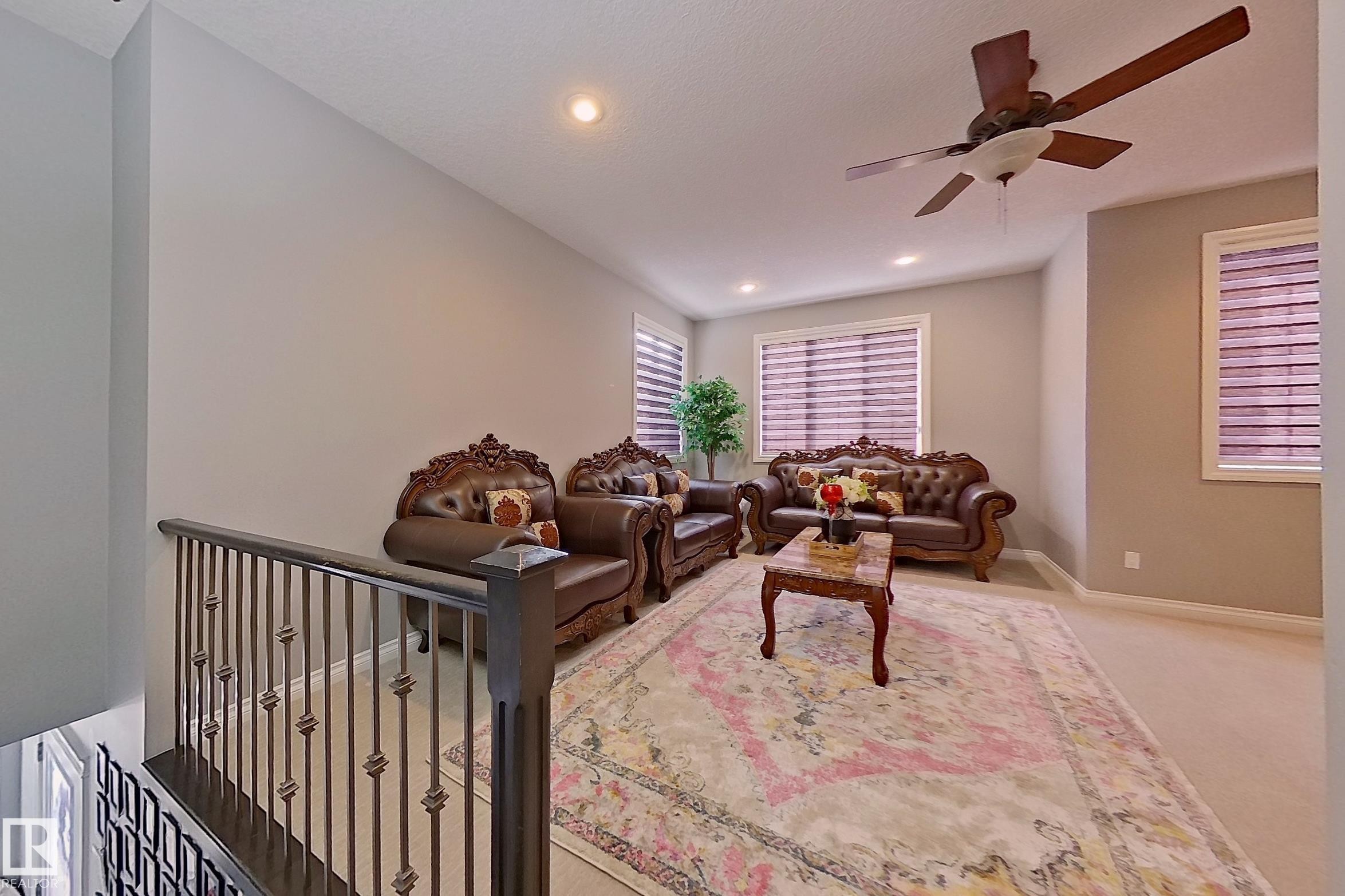 This inviting living area features neutral-toned walls, recessed lighting, and a ceiling fan for comfort - 1743 60 Street Sw, Edmonton, AB - Indoor
