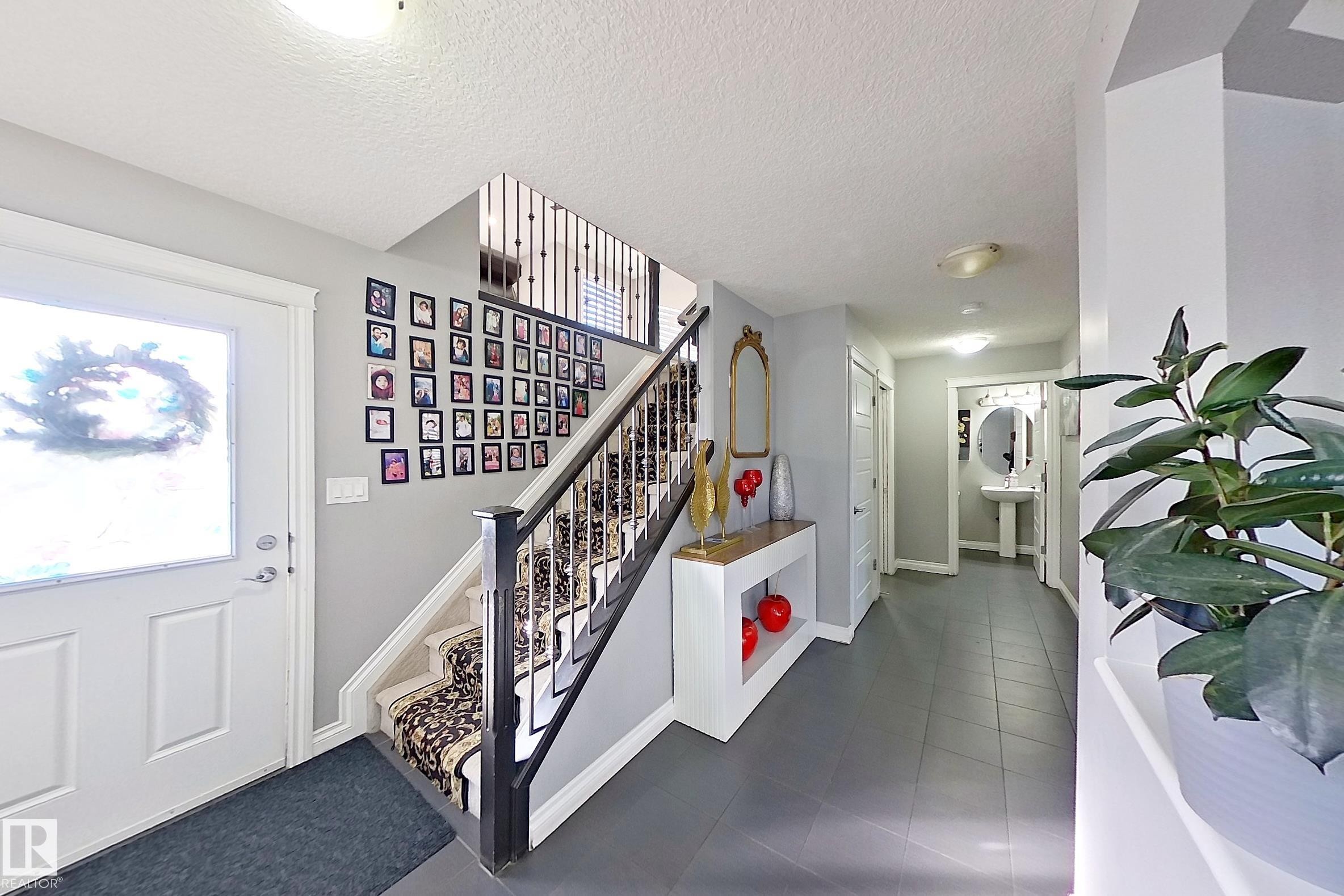 The property features a welcoming entryway with light gray walls and dark tile flooring - 1743 60 Street Sw, Edmonton, AB - Indoor Photo Showing Other Room