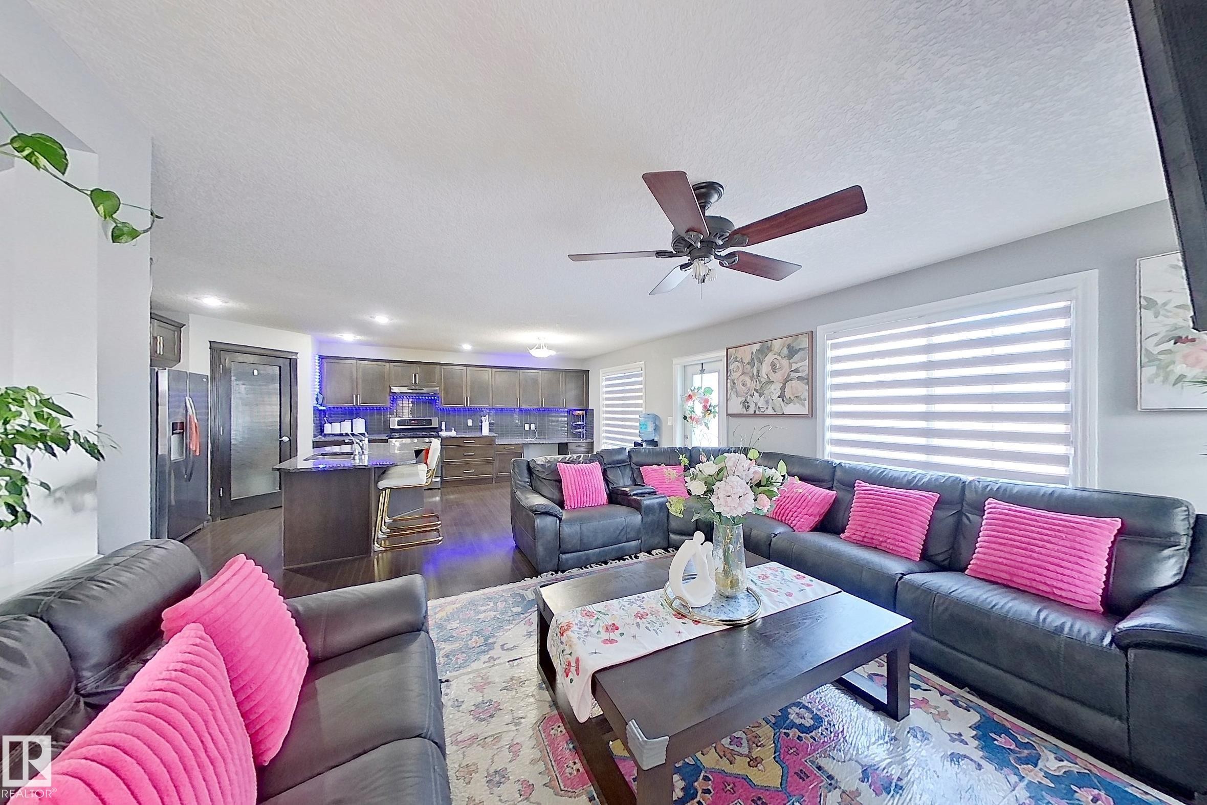 Spacious living area featuring dark hardwood floors, a ceiling fan, and large windows with blinds - 1743 60 Street Sw, Edmonton, AB - Indoor Photo Showing Living Room