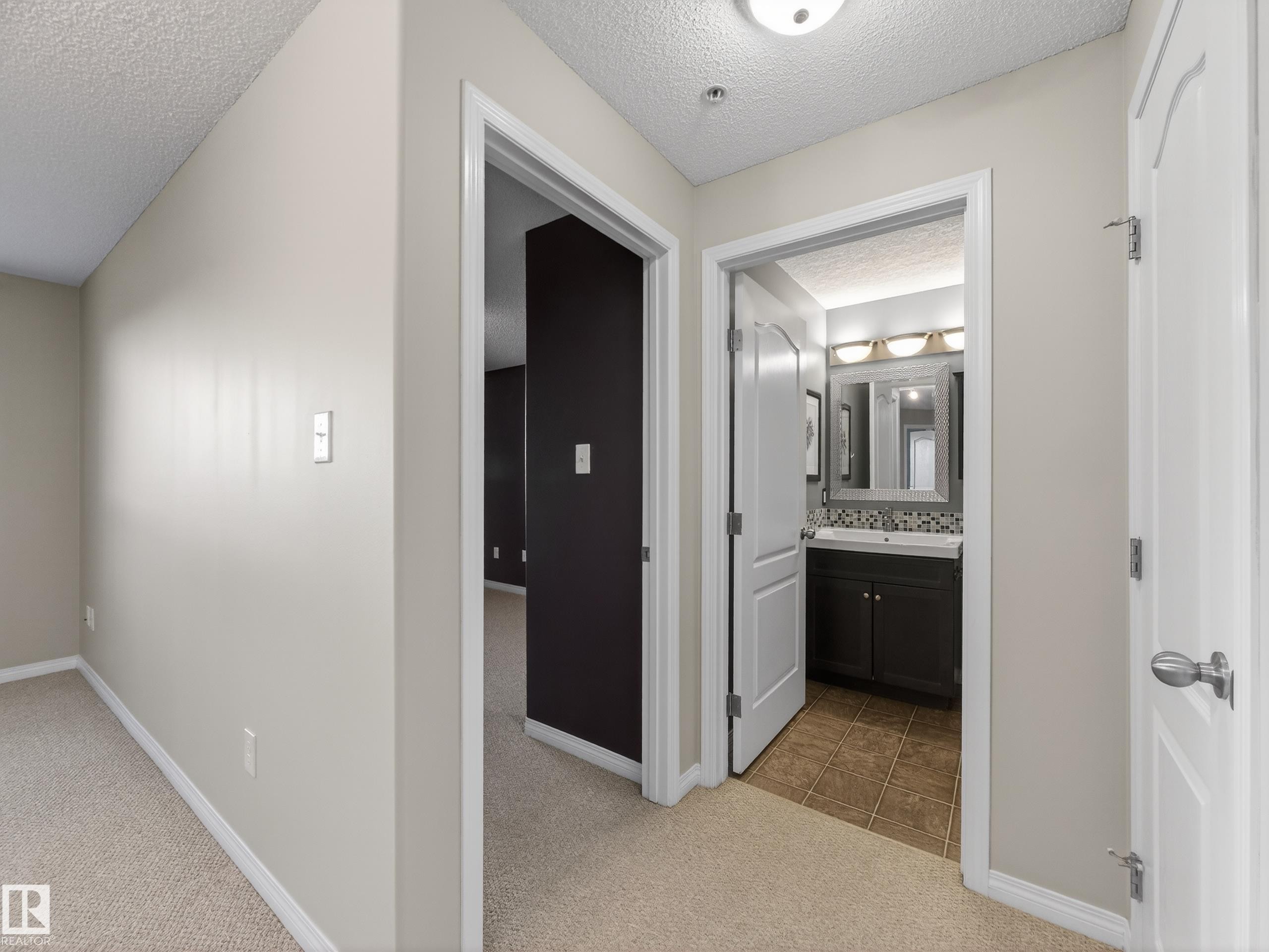 Hallway with light beige carpeting and neutral-toned walls - 1111 9363 Simpson Drive, Edmonton, AB - Indoor Photo Showing Other Room
