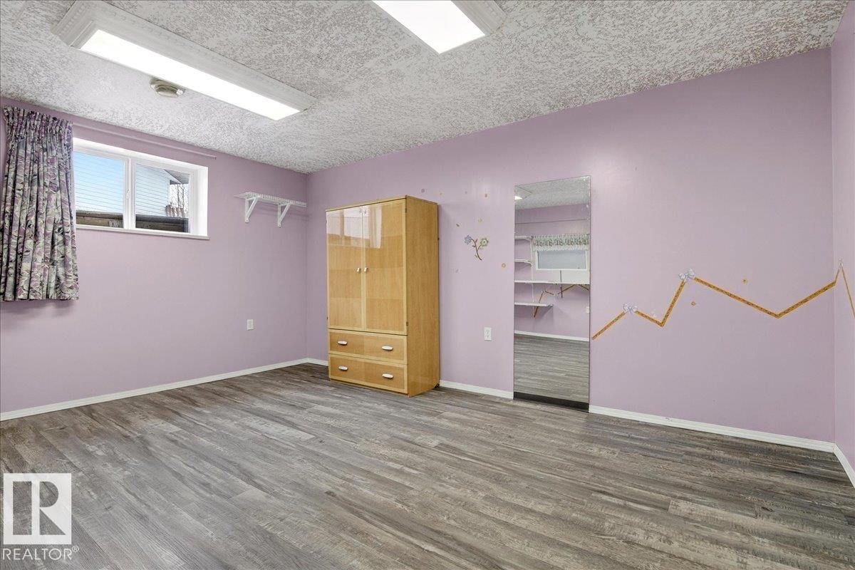 This versatile room features light purple walls and durable wood-look flooring - 4412 Yeoman Close, Onoway, AB - Indoor