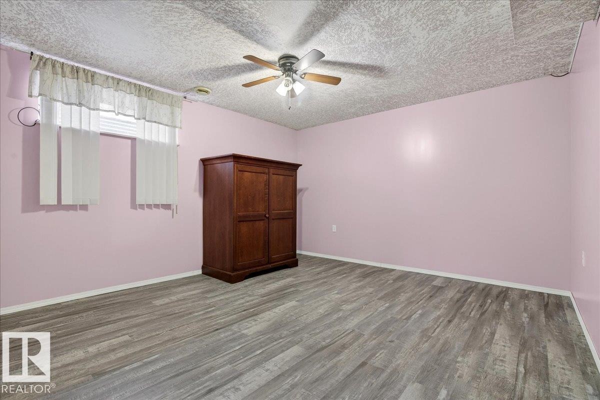 Room featuring light-toned walls, wood-style flooring, and a ceiling fan with integrated lighting - 4412 Yeoman Close, Onoway, AB - Indoor Photo Showing Other Room