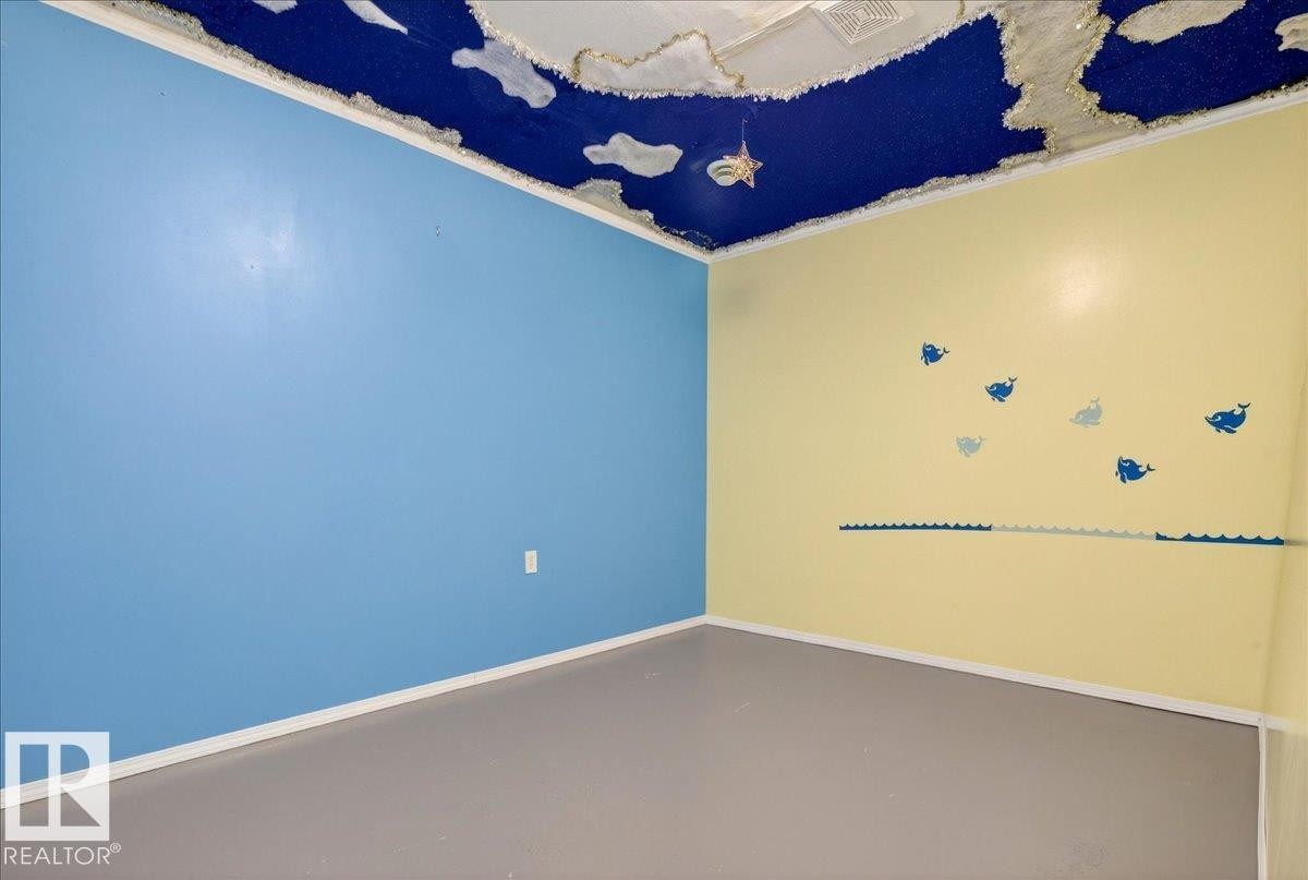 This room features walls painted in light blue and yellow, with a dark blue ceiling that includes cloud-like accents - 4412 Yeoman Close, Onoway, AB - Other