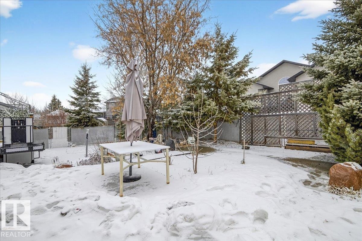The property features a fenced backyard with various trees and a patio area - 4412 Yeoman Close, Onoway, AB - Outdoor