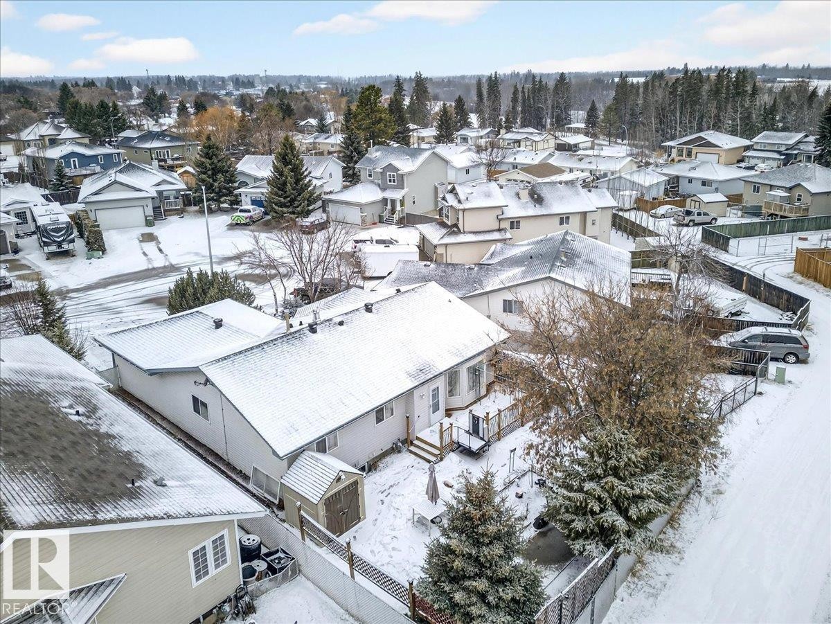 The property features a backyard with a wooden deck and a storage shed - 4412 Yeoman Close, Onoway, AB - Outdoor With View