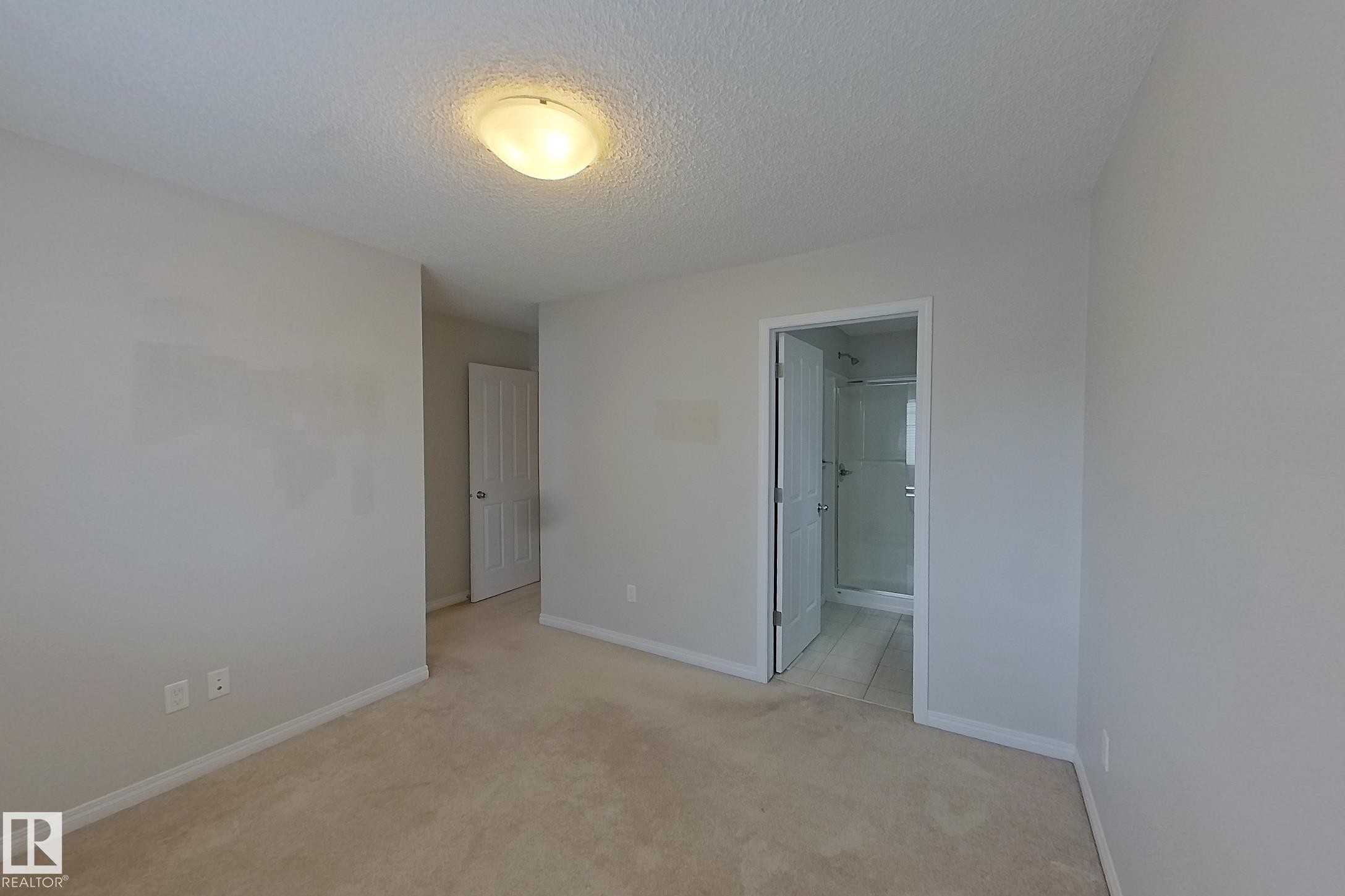 Carpeted room featuring light-colored walls and a ceiling-mounted light fixture - 87 4050 Savaryn Drive, Edmonton, AB - Indoor Photo Showing Other Room