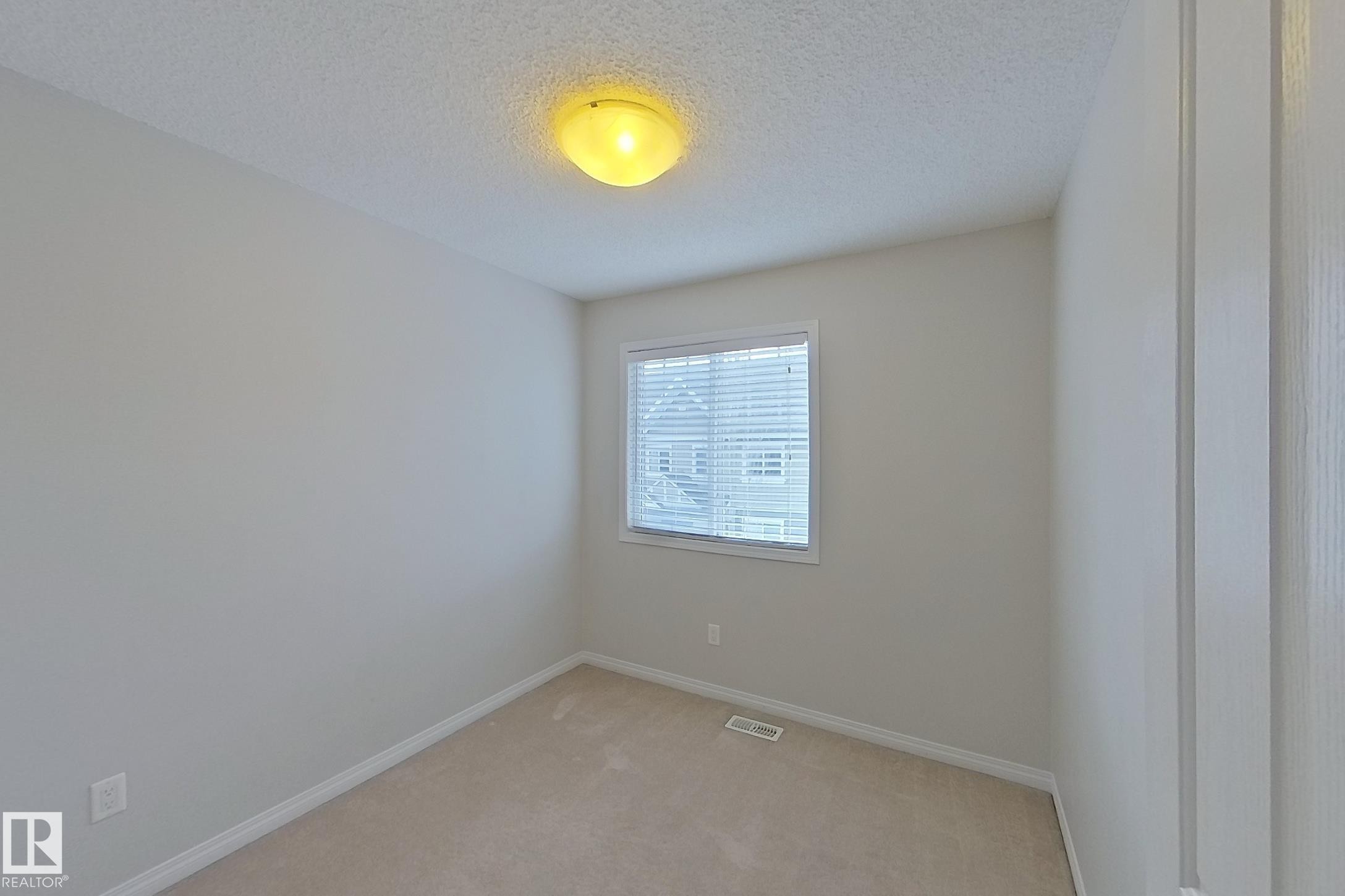 This room features light-colored walls and carpeted flooring - 87 4050 Savaryn Drive, Edmonton, AB - Indoor Photo Showing Other Room