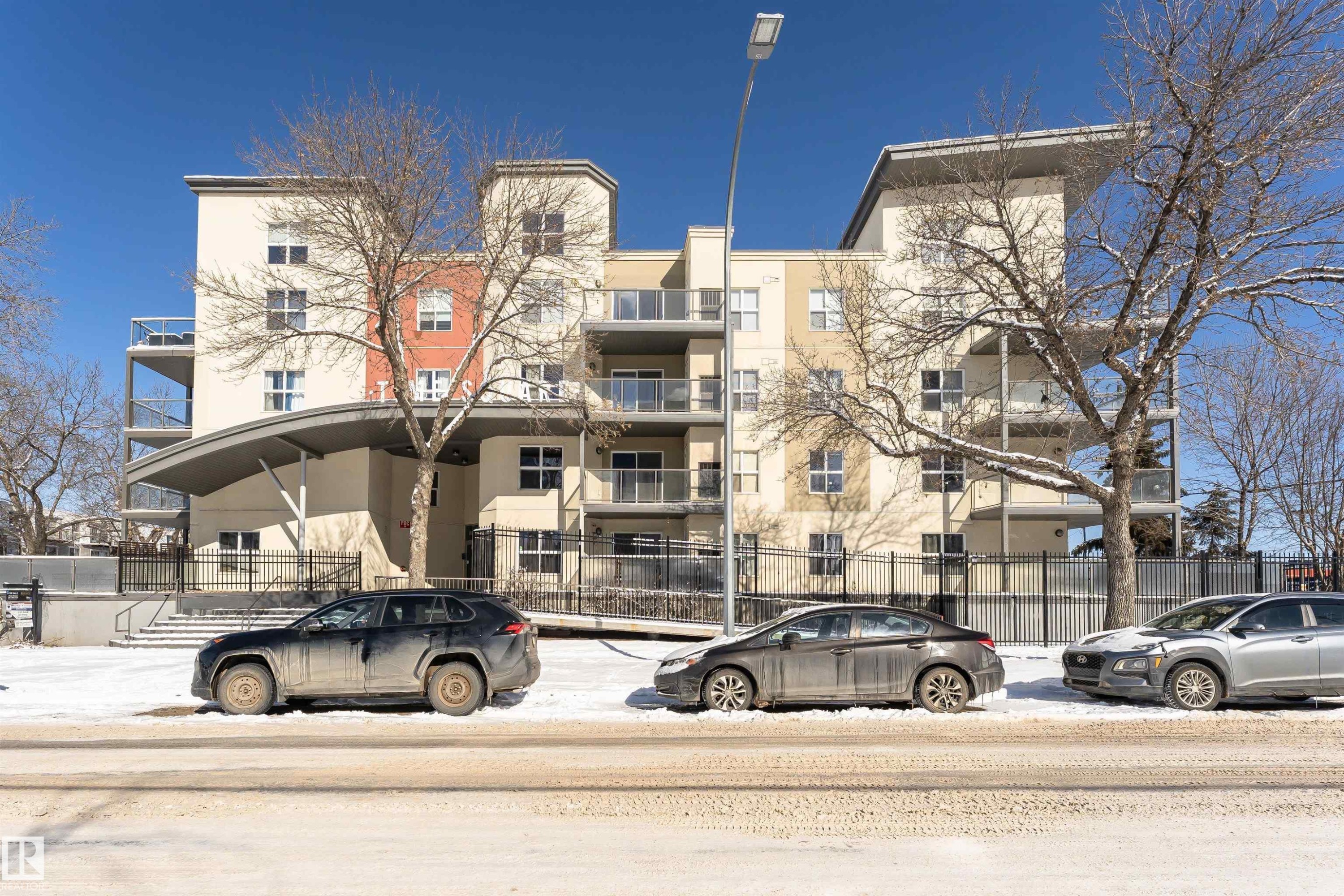 The property features a multi-story building with a light-colored facade and balconies - 107 10118 106 Avenue, Edmonton, AB - Outdoor