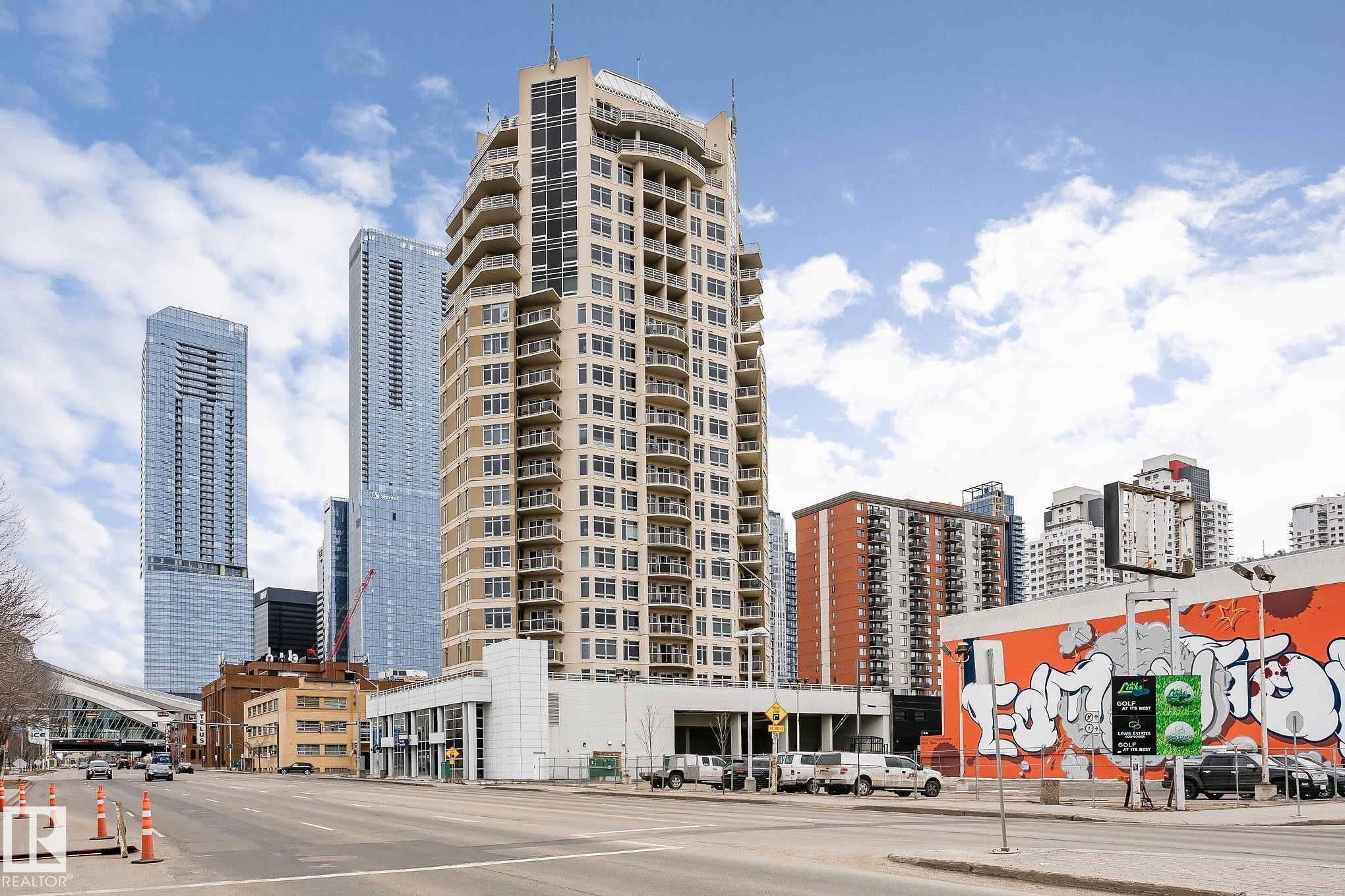 The property is a high-rise building with numerous balconies, situated in an urban environment with other high-rise buildings and commercial properties visible - 107 10118 106 Avenue, Edmonton, AB - Outdoor With Facade
