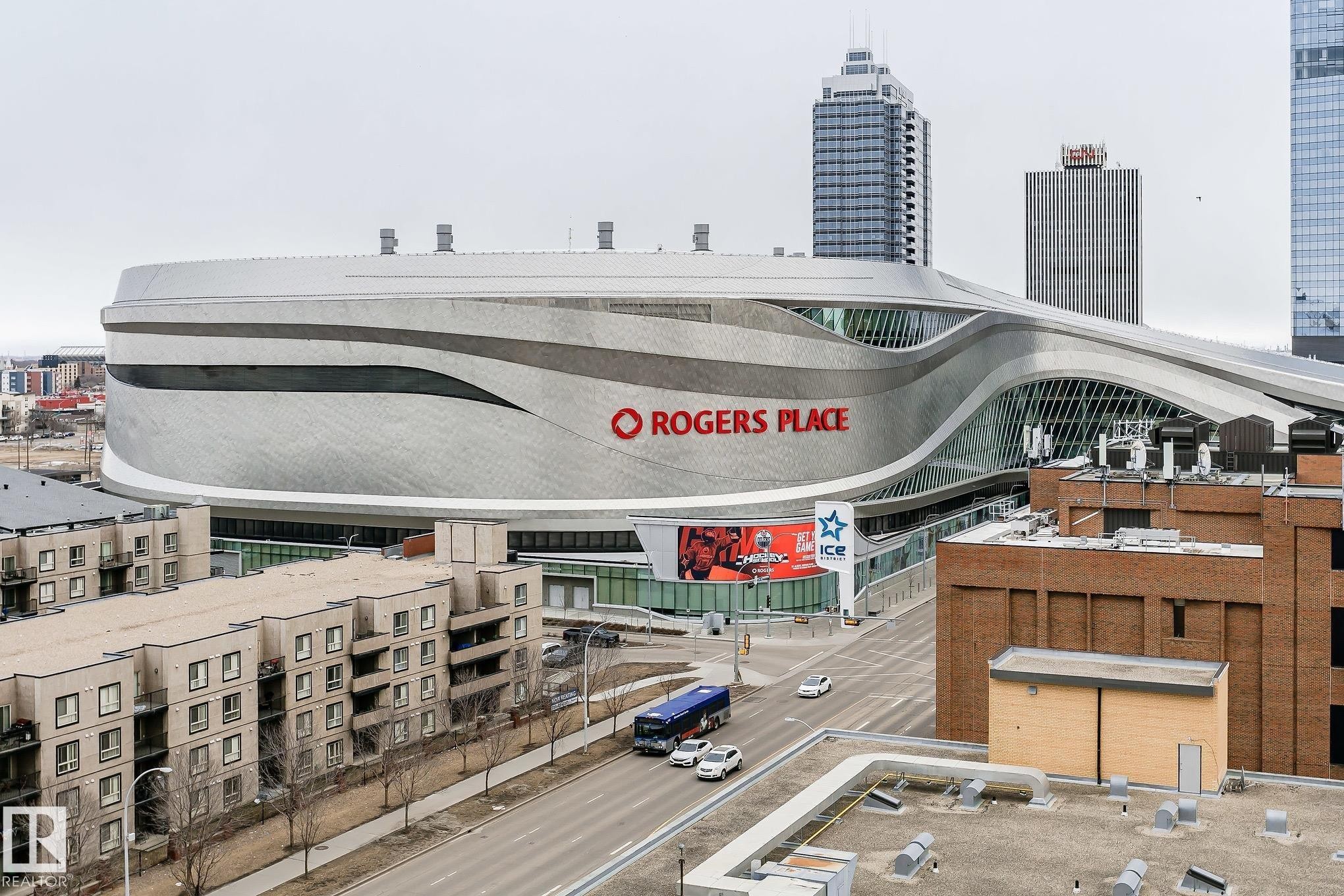 The property is located in a vibrant urban setting with views of a modern stadium and surrounding cityscape - 107 10118 106 Avenue, Edmonton, AB - Outdoor