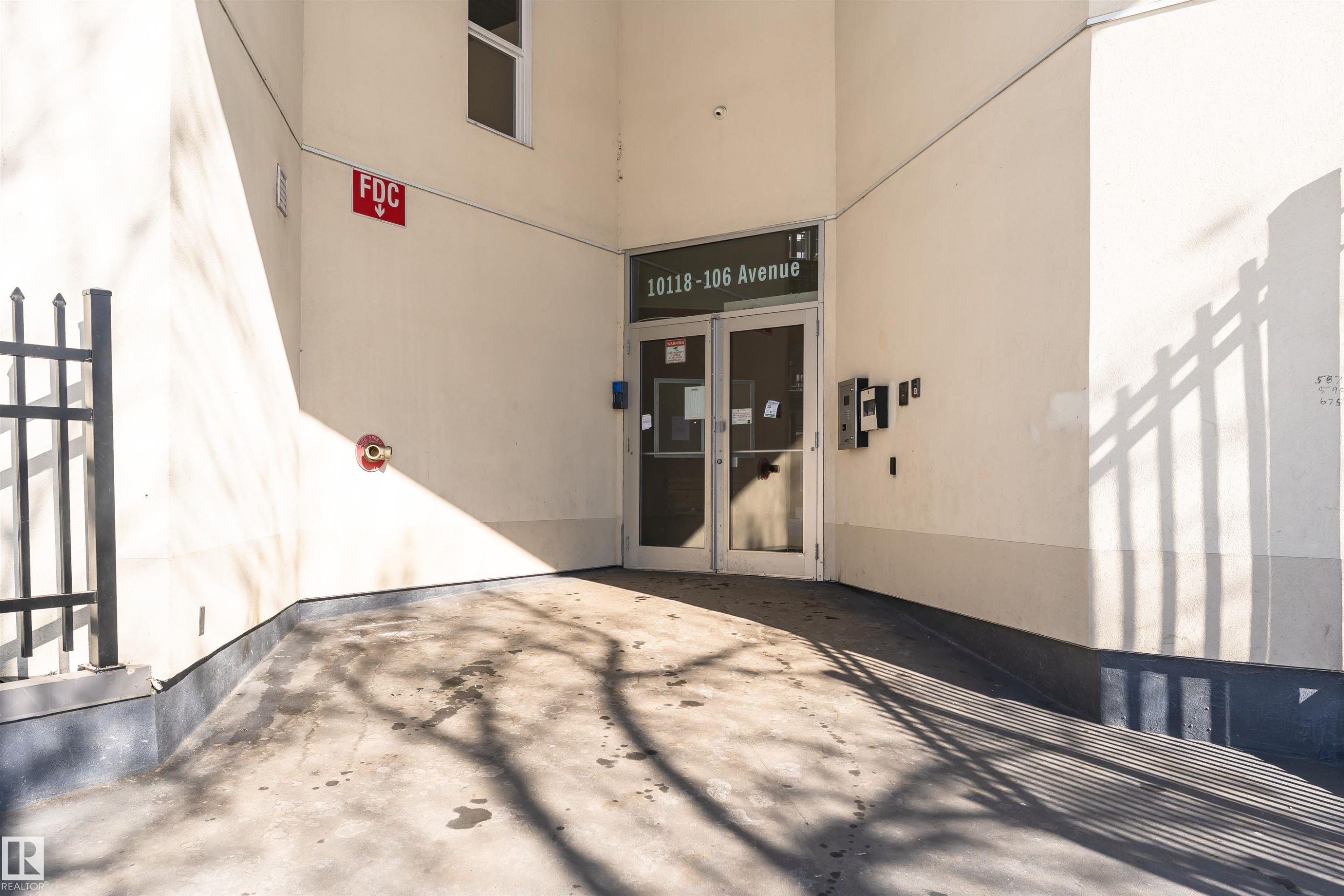 Property entrance featuring double glass doors and an exterior security panel - 107 10118 106 Avenue, Edmonton, AB - Photo Showing Other Room