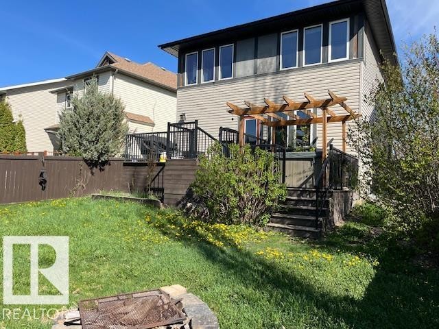 Multi-level rear deck with black railings, a wooden pergola, and privacy screening - 21917 95A Avenue, Edmonton, AB - Outdoor
